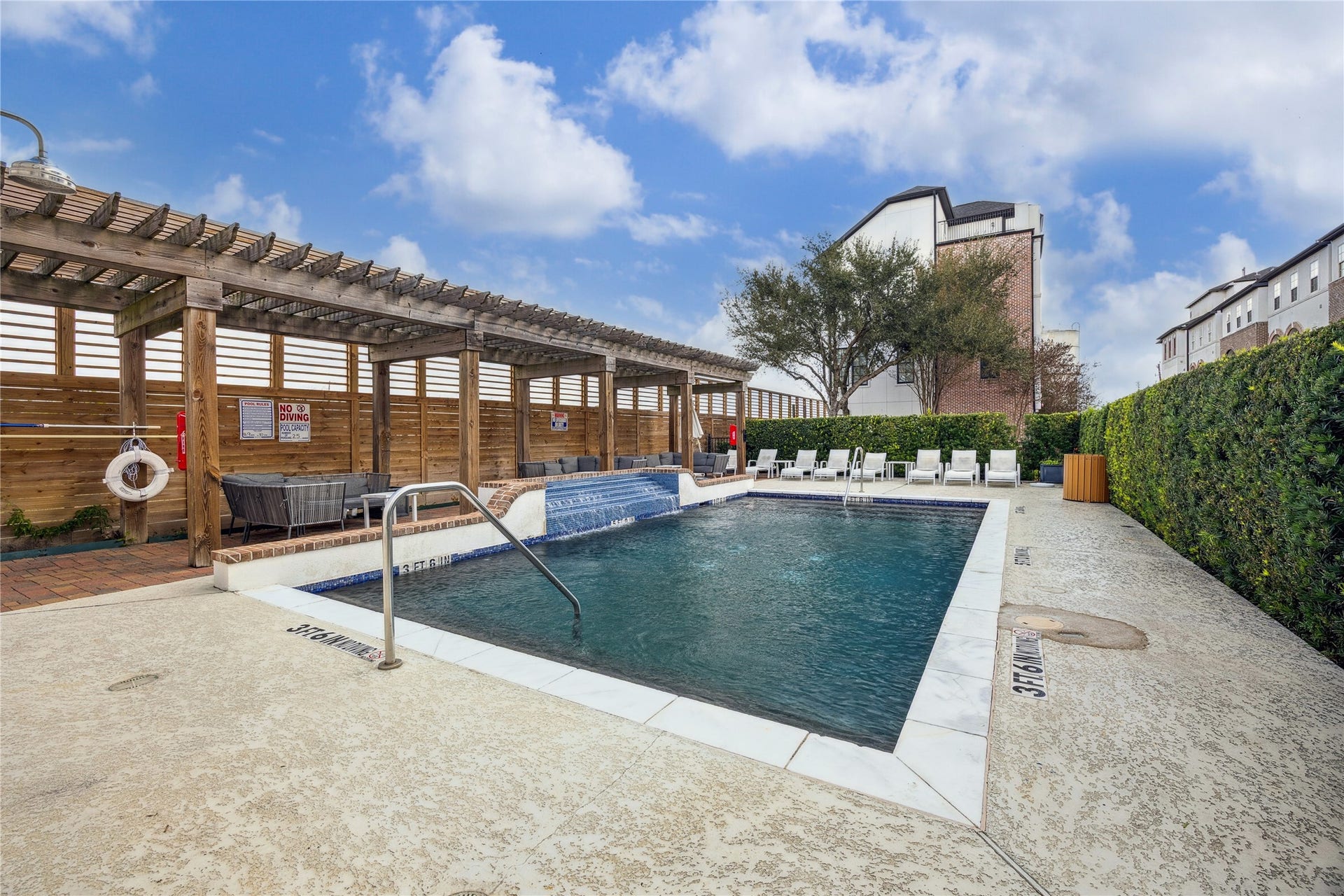 2725 Cohn Garden, Houston, TX 77007 A resort style pool is framed by a wood pergola, brick accents, and cushioned lounge seating for shaded relaxation. Open deck space and privacy hedges create a clean, inviting setting for warm weather afternoons.