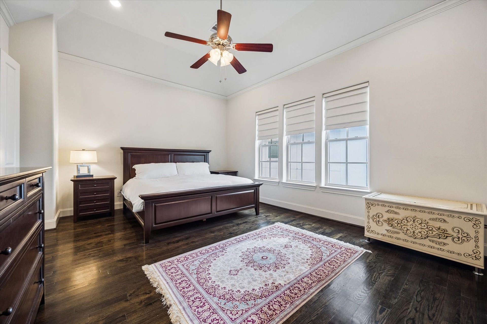 2725 Cohn Garden, Houston, TX 77007 Three tall windows bring natural light into the spacious primary suite, complemented by rich hardwood floors, a tray ceiling, and generous wall space.