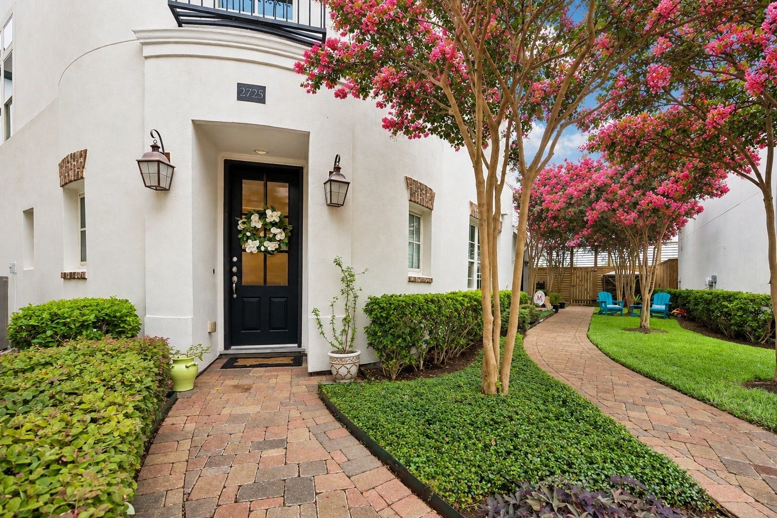 2725 Cohn Garden, Houston, TX 77007 A charming brick walkway winds through manicured landscaping beneath vibrant crepe myrtles, creating a private, garden like approach to the home. The recessed entry and classic lanterns add warmth to the crisp stucco exterior.