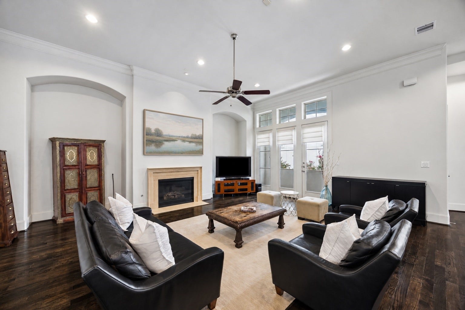 2725 Cohn Garden, Houston, TX 77007 High ceilings and a wall of windows give the main living area an open, light filled feel. A gas fireplace anchors the room.