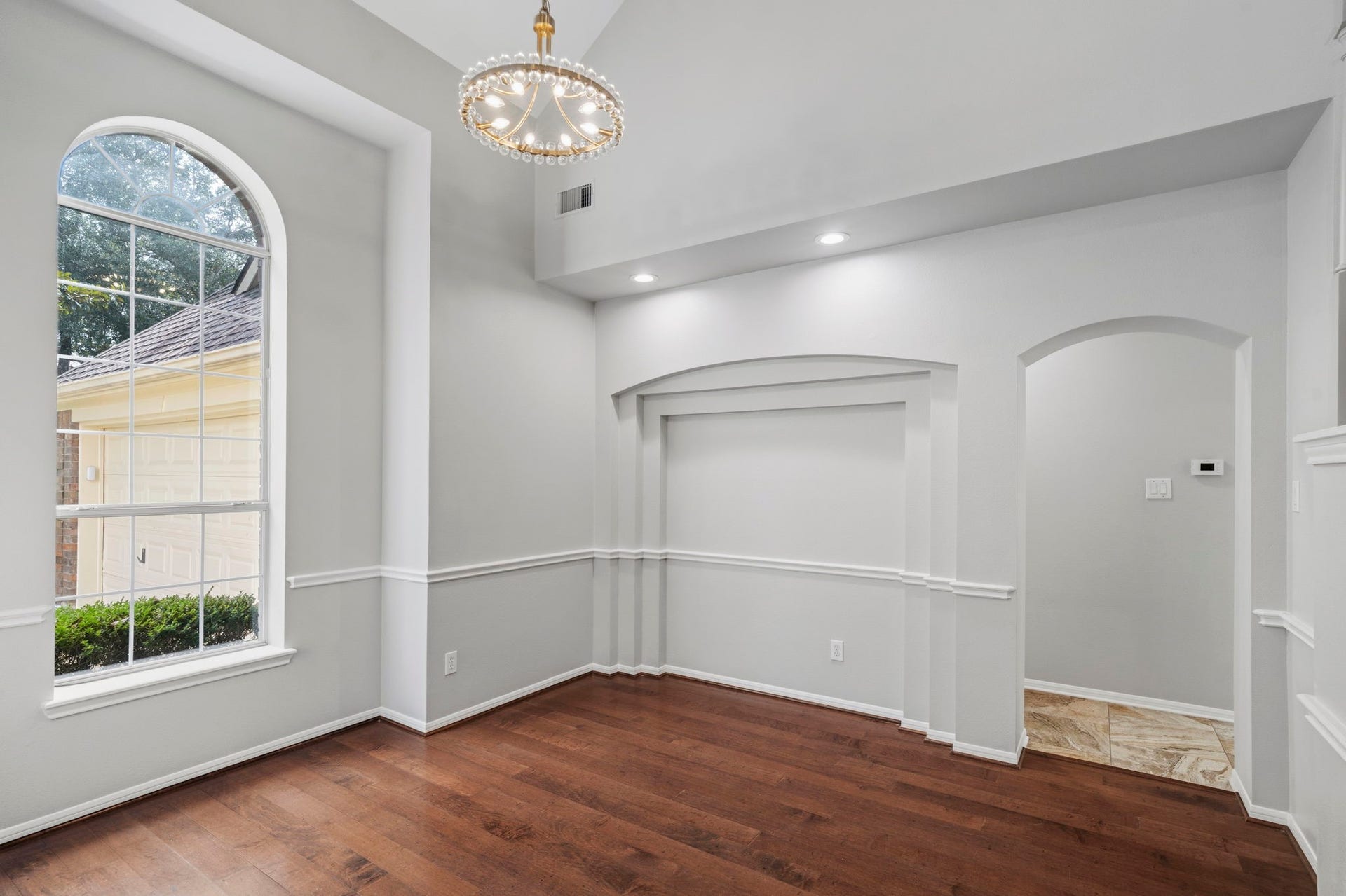 3427 Powell Way, Missouri City, TX 77459 Refined formal space with an arched window and statement chandelier.