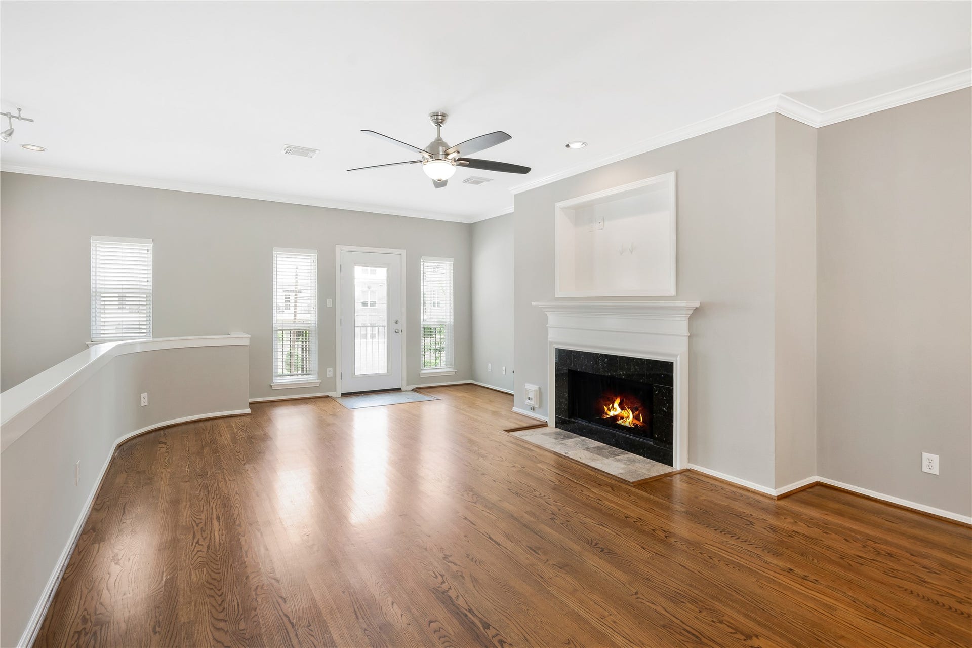 2615 W Dallas Street, Houston, TX 77019 Living area with wood flooring, fireplace , ceiling fan and balcony with front view.