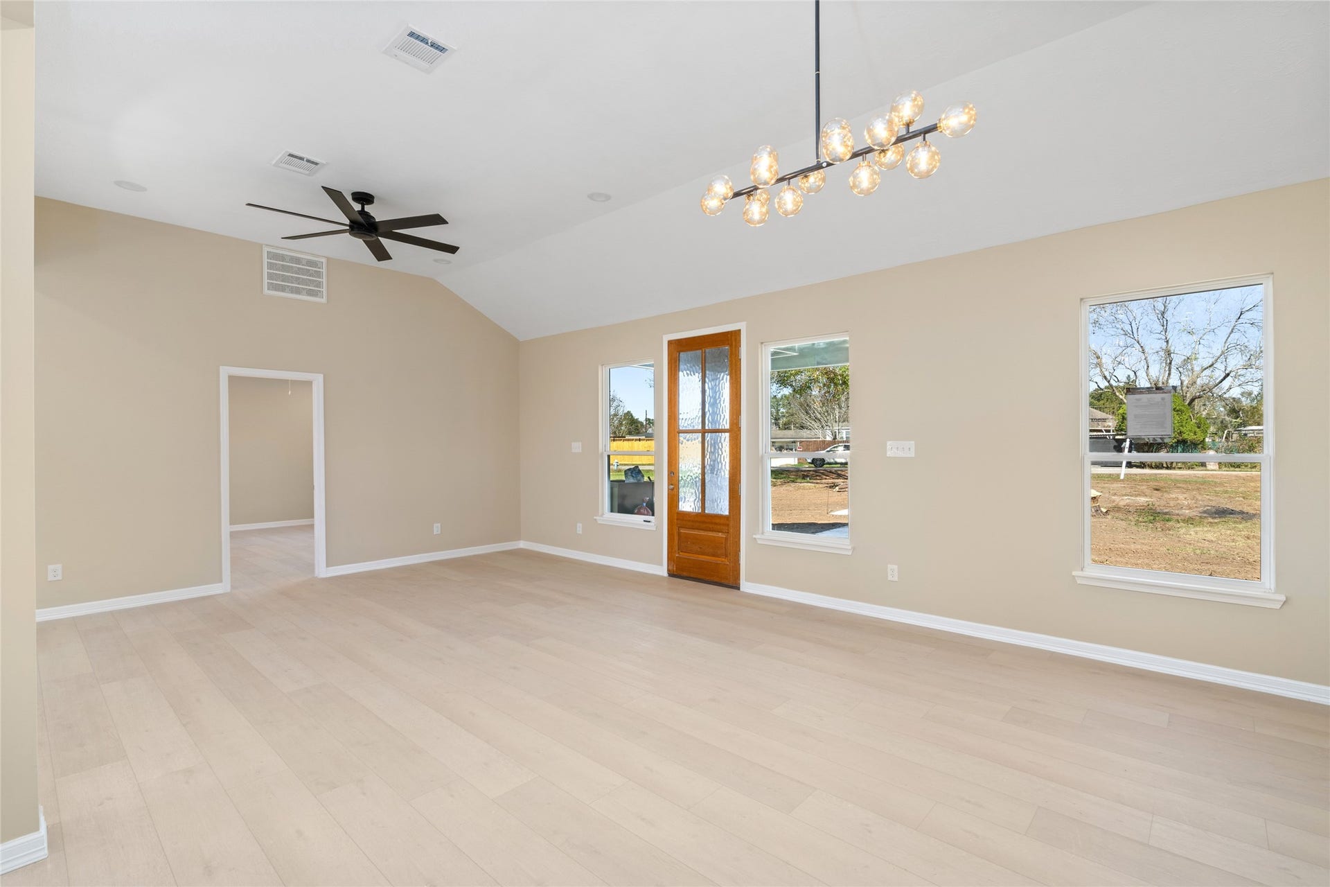 Spacious, open-concept living
room with vaulted ceilings,
expansive windows, and a
stylish ceiling fan. This wideangle view showcases
seamless flow and room for
every lifestyle.