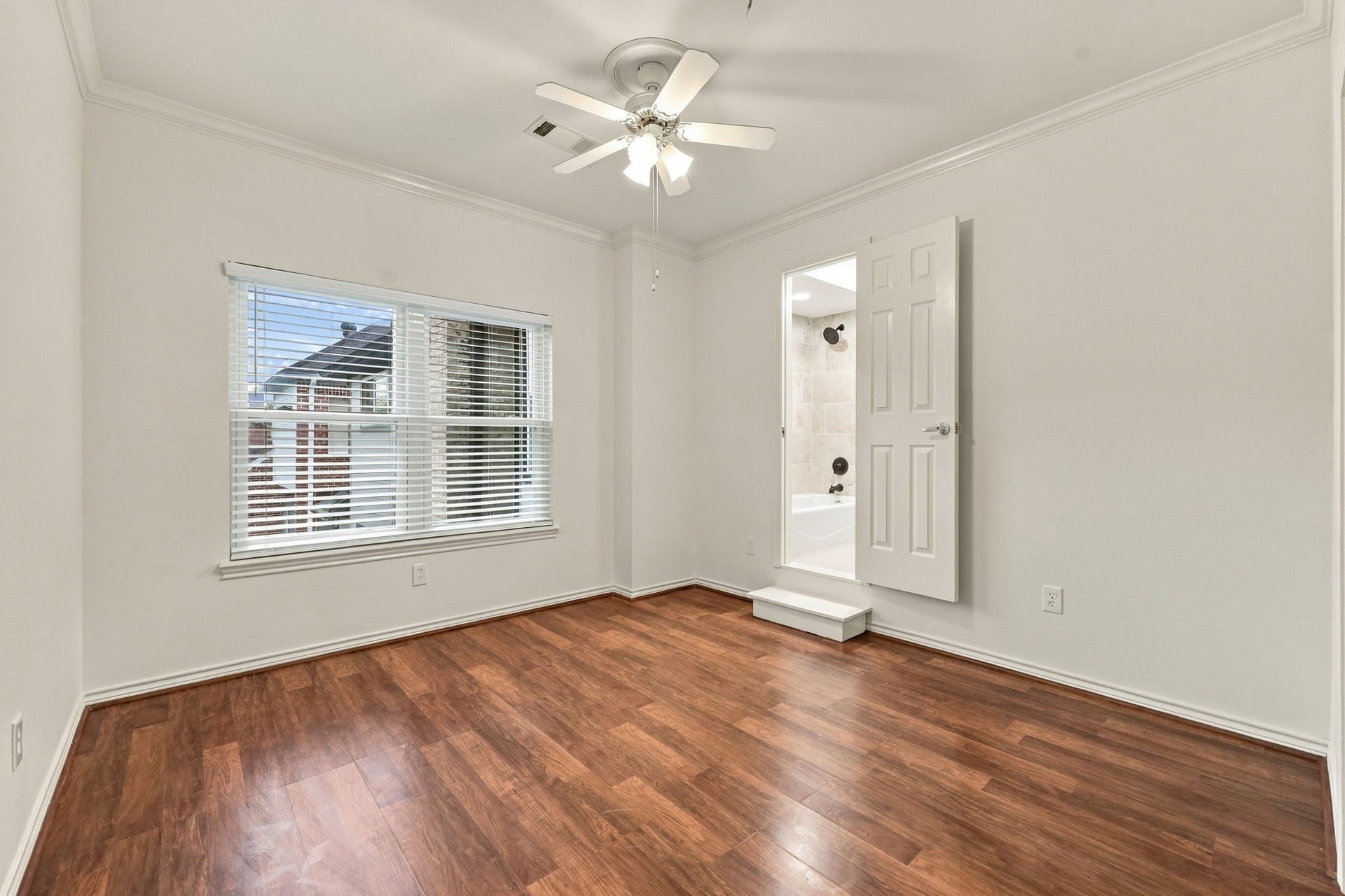 1430 Stependale Drive, Katy, TX 77450 Garage Apt- Bright bedroom with wood-look flooring, a ceiling fan, and a window overlooking the surrounding area.Door connecting to main house if desired.