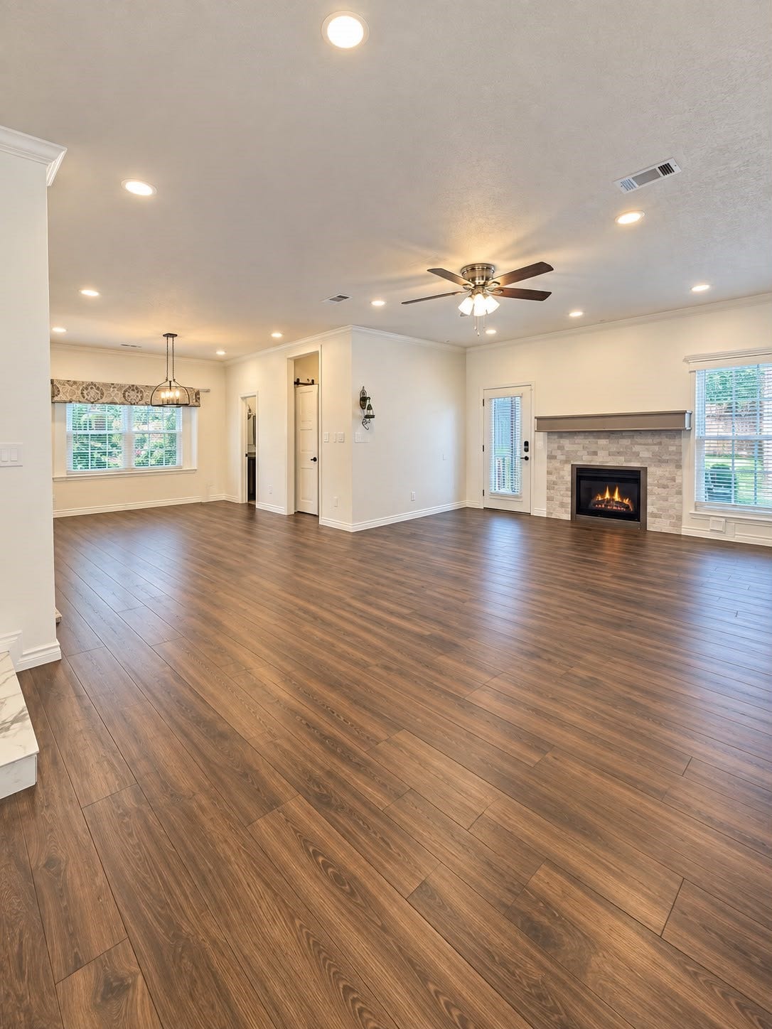 1430 Stependale Drive, Katy, TX 77450 Spacious living room with wood-look flooring, recessed lighting, a fireplace, and a large wall-mounted TV.