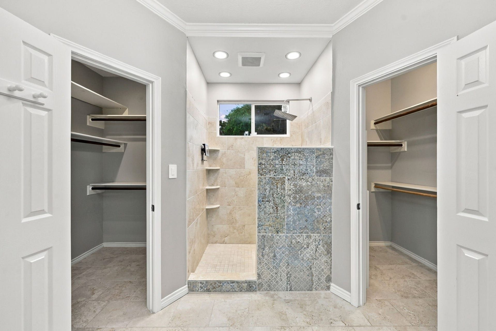 1430 Stependale Drive, Katy, TX 77450 Spacious walk-in shower with decorative tile detailing, recessed lighting, and dual walk-in closets on either side.