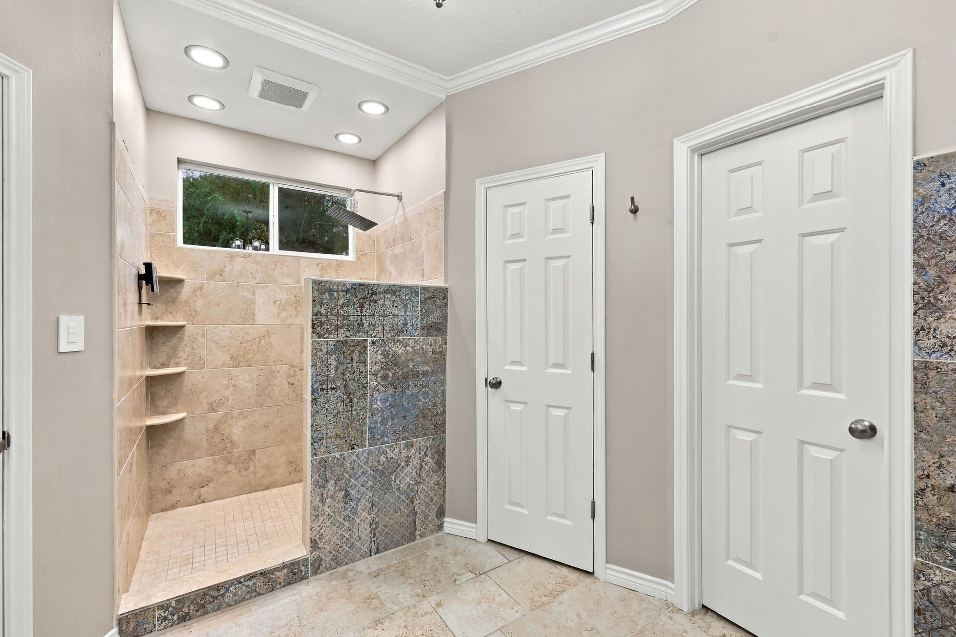 1430 Stependale Drive, Katy, TX 77450 Spacious walk-in shower with decorative tile detailing, built-in shelving, and modern fixtures.