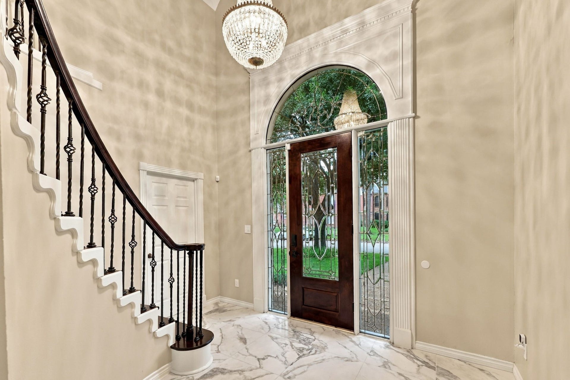1430 Stependale Drive, Katy, TX 77450 Grand entry foyer featuring marble-look flooring, a decorative chandelier, and a sweeping staircase with dark wood railings.
