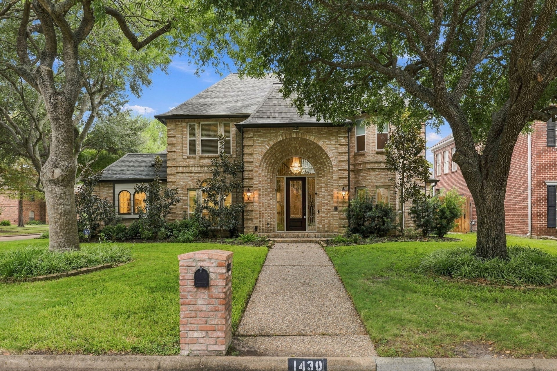 1430 Stependale Drive, Katy, TX 77450 Impressive two-story brick residence situated on a corner lot, showcasing mature trees, manicured landscaping, and a welcoming entry.