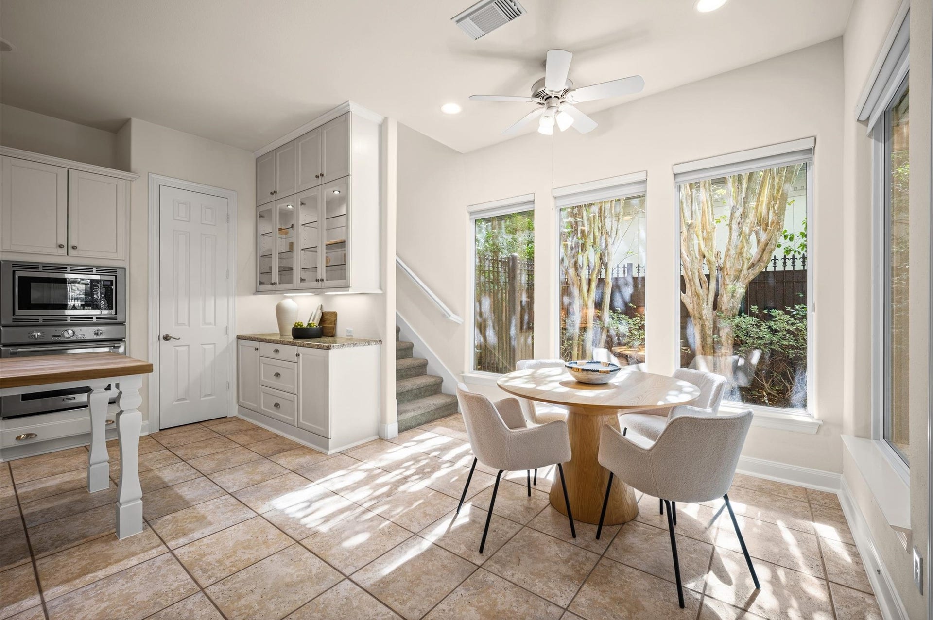 3010 Bonnebridge Way Boulevard, Houston, TX 77082 Bathed in natural light, the breakfast nook offers an inviting setting for quiet mornings and casual meals, with expansive windows framing lush, mature landscaping that creates a serene sense of privacy.