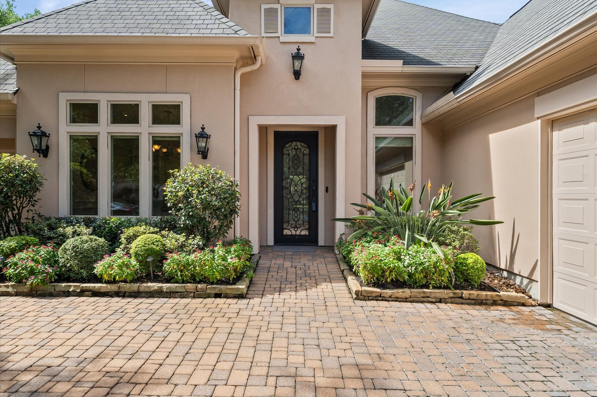 3010 Bonnebridge Way Boulevard, Houston, TX 77082 A beautifully landscaped courtyard welcomes you home, with a paver walkway leading to an elegant iron-and-glass front door framed by lush greenery
