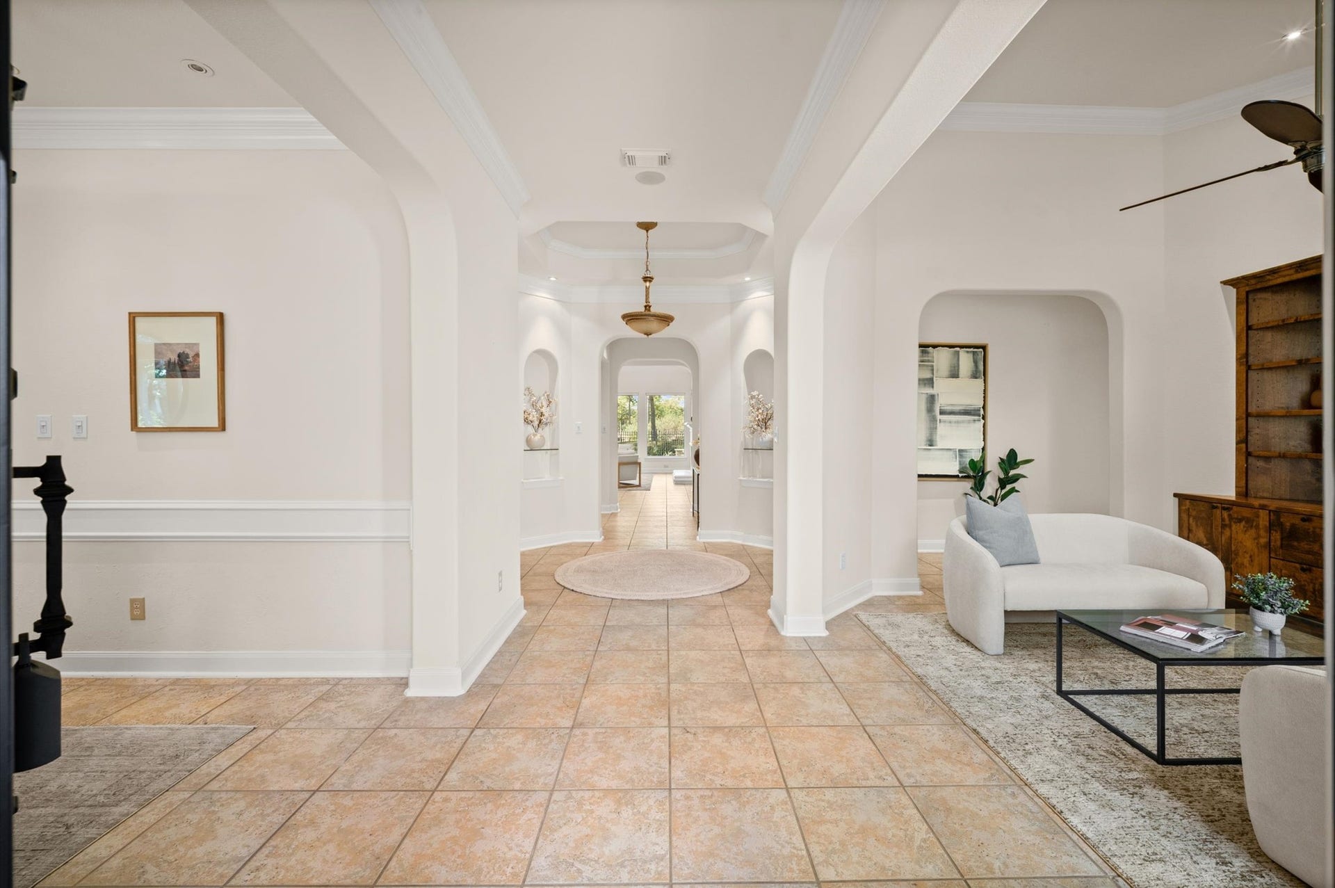 3010 Bonnebridge Way Boulevard, Houston, TX 77082 The entry hall is framed by the formal dining room to the left and an open study to the right, with soft architectural arches and layered ceiling details drawing the eye through the home. A second, private office upstairs offers a quieter workspace with golf course views.