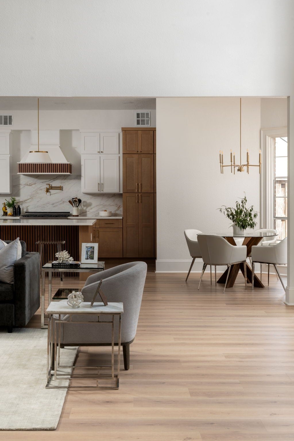 The breakfast area is surrounded by oversized windows and views of the backyard and patio spaces beyond. Vaulted ceilings and updated lighting enhance the openness of the room while maintaining a casual dining atmosphere. Positioned adjacent to the kitchen, the space supports both everyday living and entertaining.