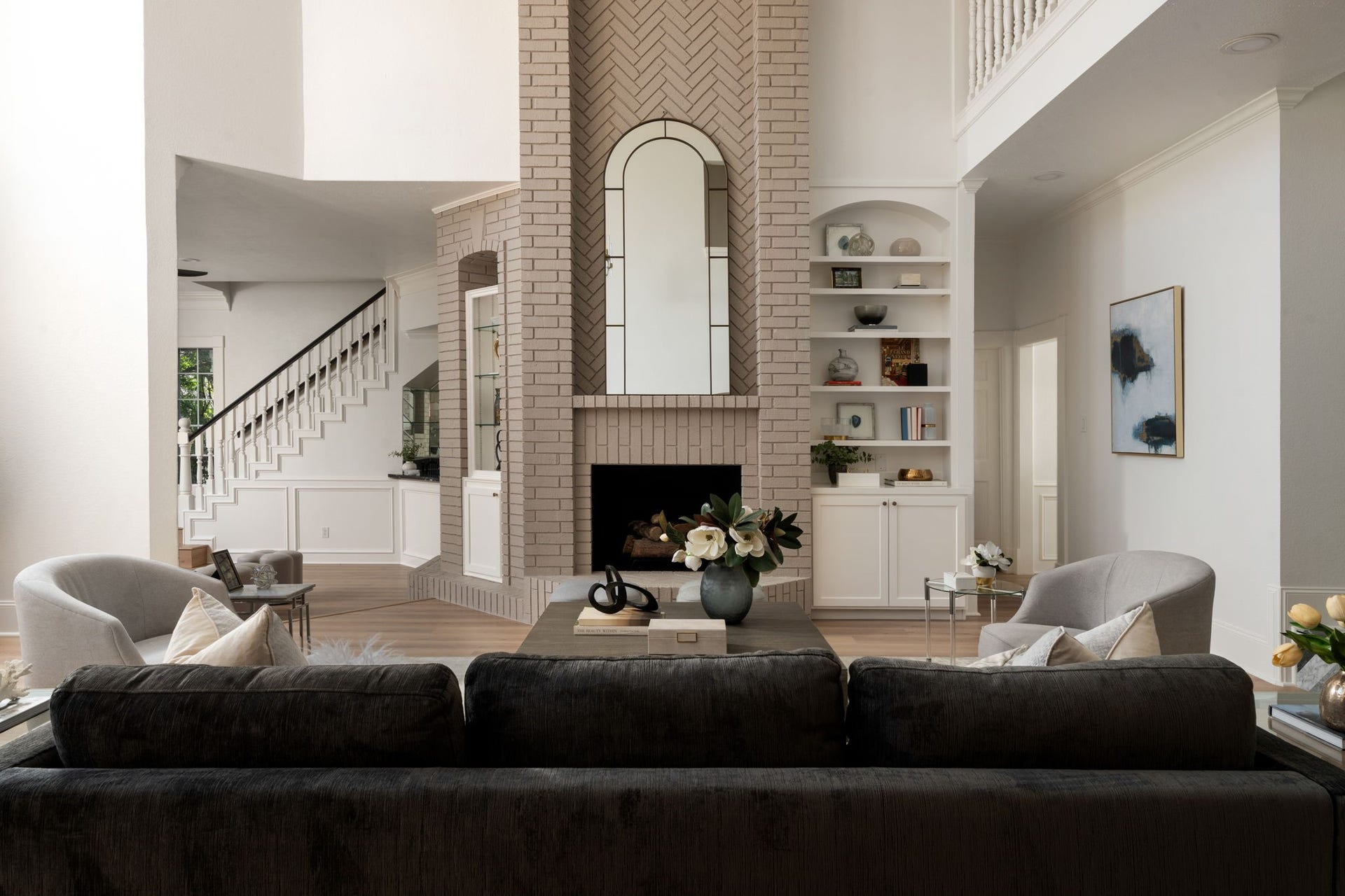 Open transitions between the main living, dining, and kitchen spaces create a layout designed for both large-scale entertaining and everyday comfort. Expansive ceiling heights and oversized windows reinforce the homes architectural scale. Contemporary finishes and layered lighting continue throughout the main level.