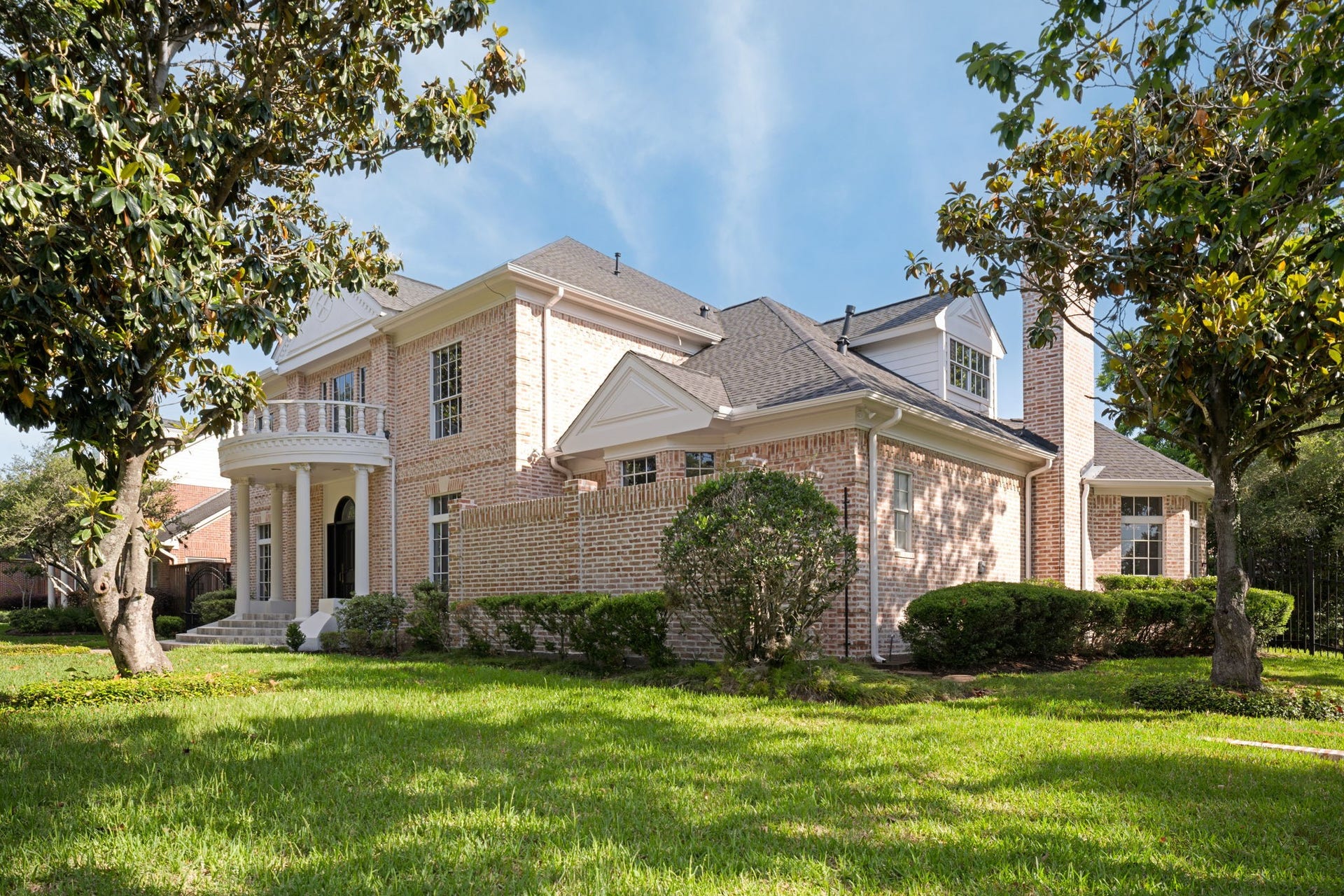 Mature oak trees and established landscaping frame the homes corner lot setting within Sweetwater Section 1. The brick exterior and manicured grounds create a timeless presence from the street. Natural greenery and shaded lawn areas enhance the overall curb appeal.