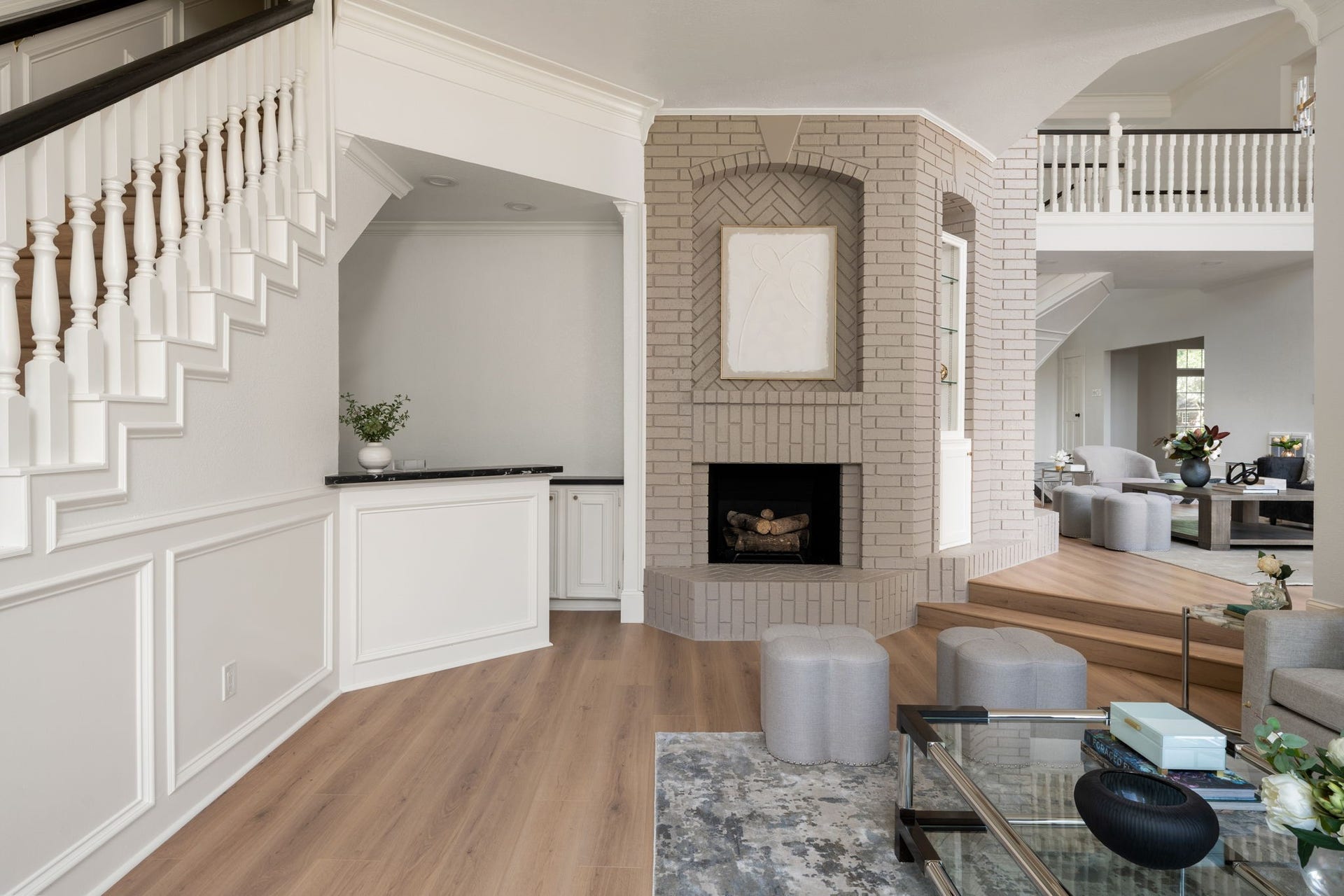 A full wet bar with mirrored backsplash, integrated sink, and marble-style surfaces adds a dedicated entertaining feature near the den and main living areas. Secondary stair access is positioned nearby, connecting the space to the upper level. Updated finishes and open transitions maintain flow throughout the surrounding spaces.