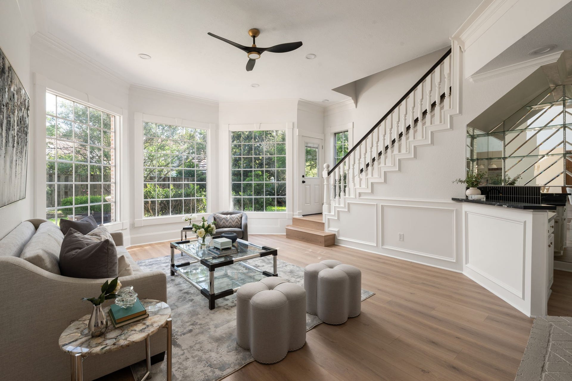 The den provides an additional gathering space overlooking the staircase and surrounding entertaining areas. Large windows, updated flooring, and clean-lined finishes continue throughout the room. Its open layout allows flexibility for casual living, media use, or lounge seating.