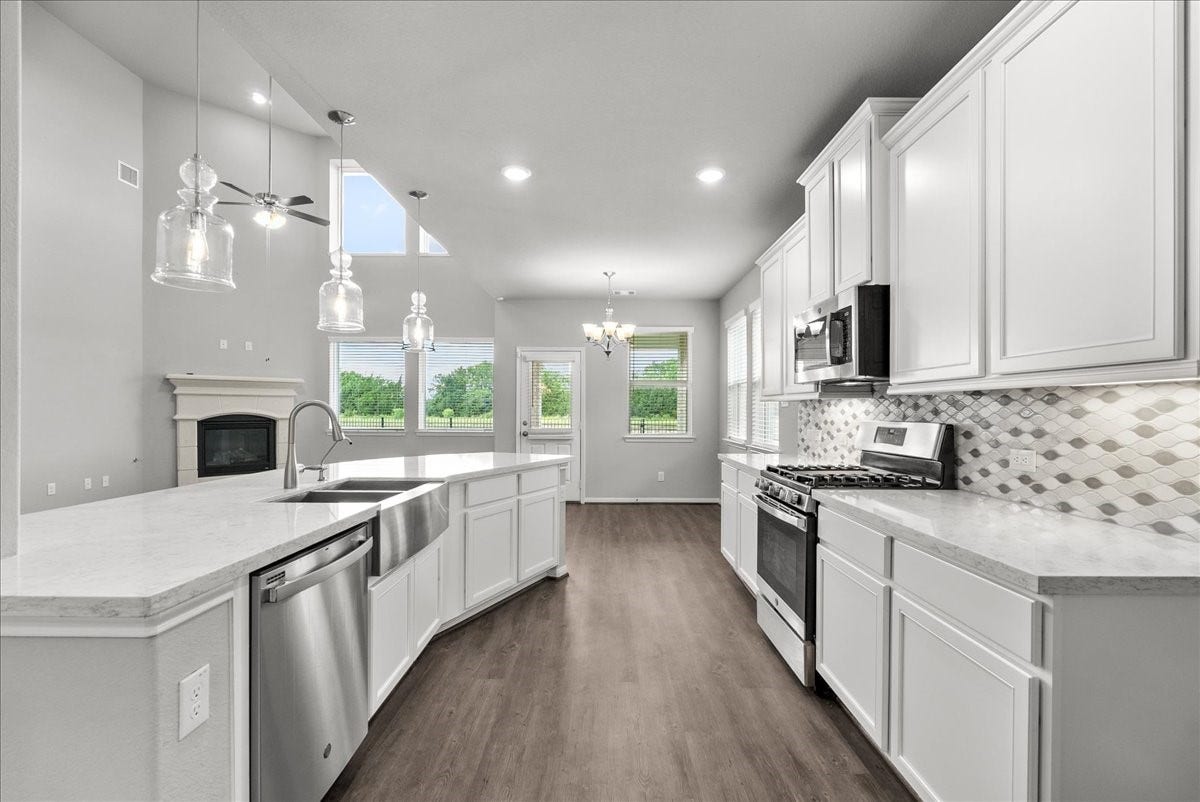 Chef's eat-in island kitchen features 42" cabinets with crown molding, stainless steel appliances and and designer backsplash