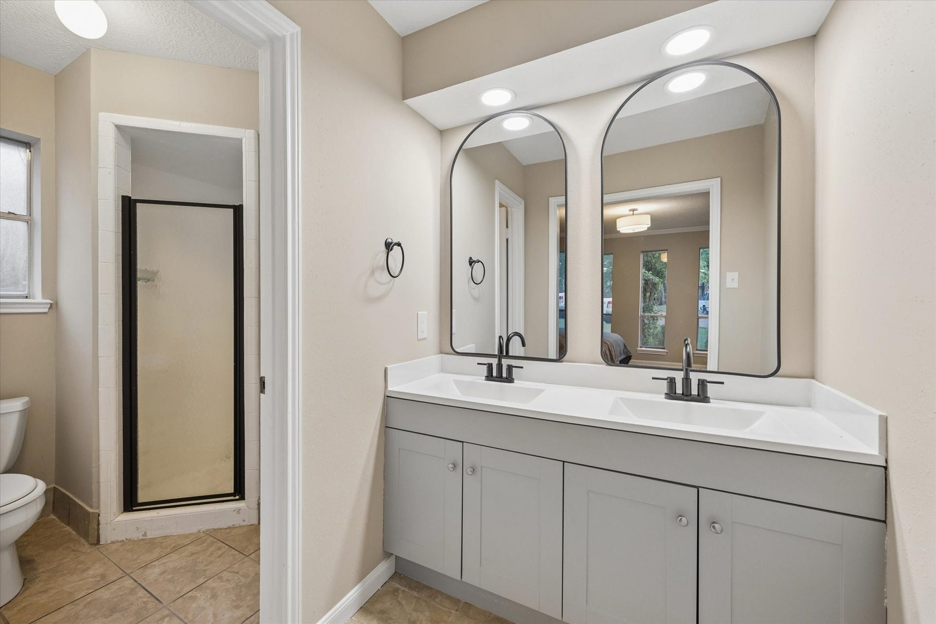 10411 Grassland Circle, Houston, TX 77070 A view of the primary restroom, with beautiful double sinks, designer mirrors, and a private shower.