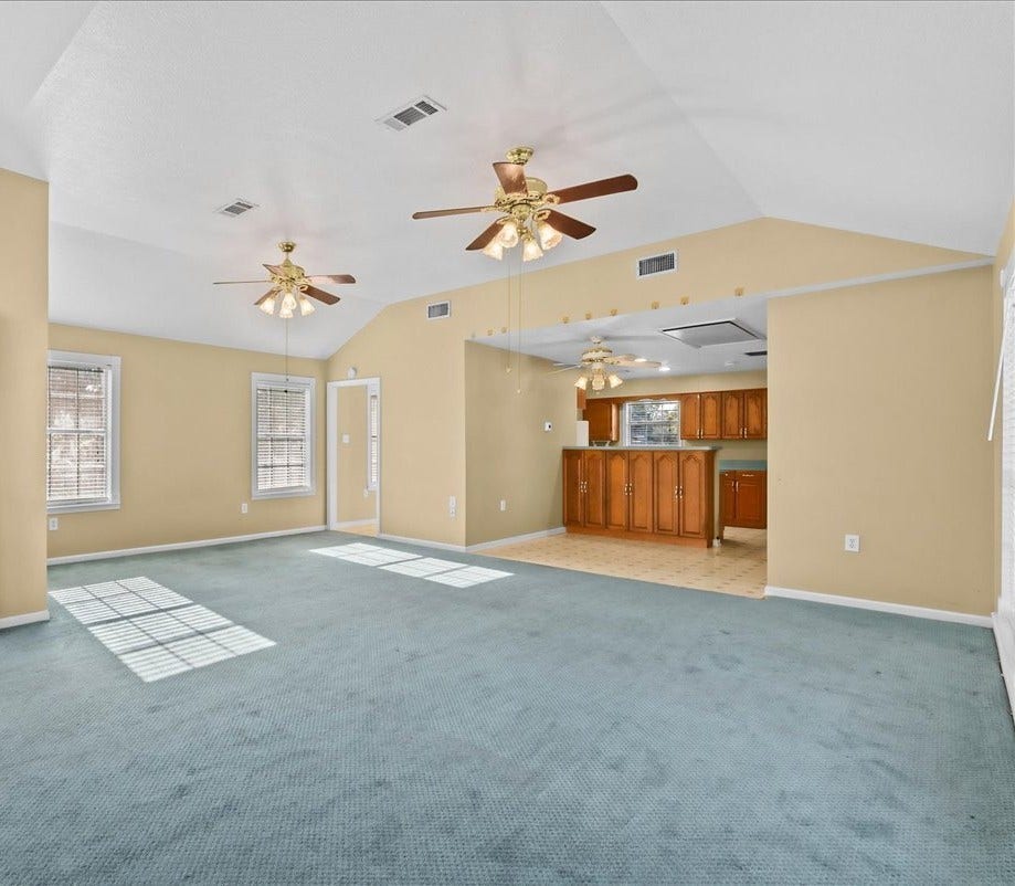 Expansive and inviting, this garage apartment living area offers ample space, enhanced by natural light and a seamless flow into the kitchen, perfect for comfortable living and entertaining.