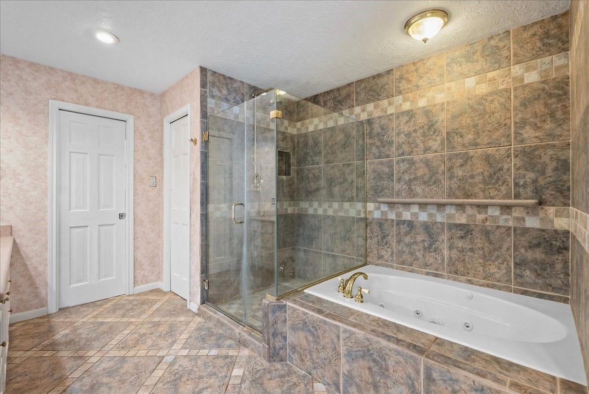 Indulge in ultimate relaxation with the luxurious jetted soaking tub and spacious shower, set in an elegant tiled bathroom.