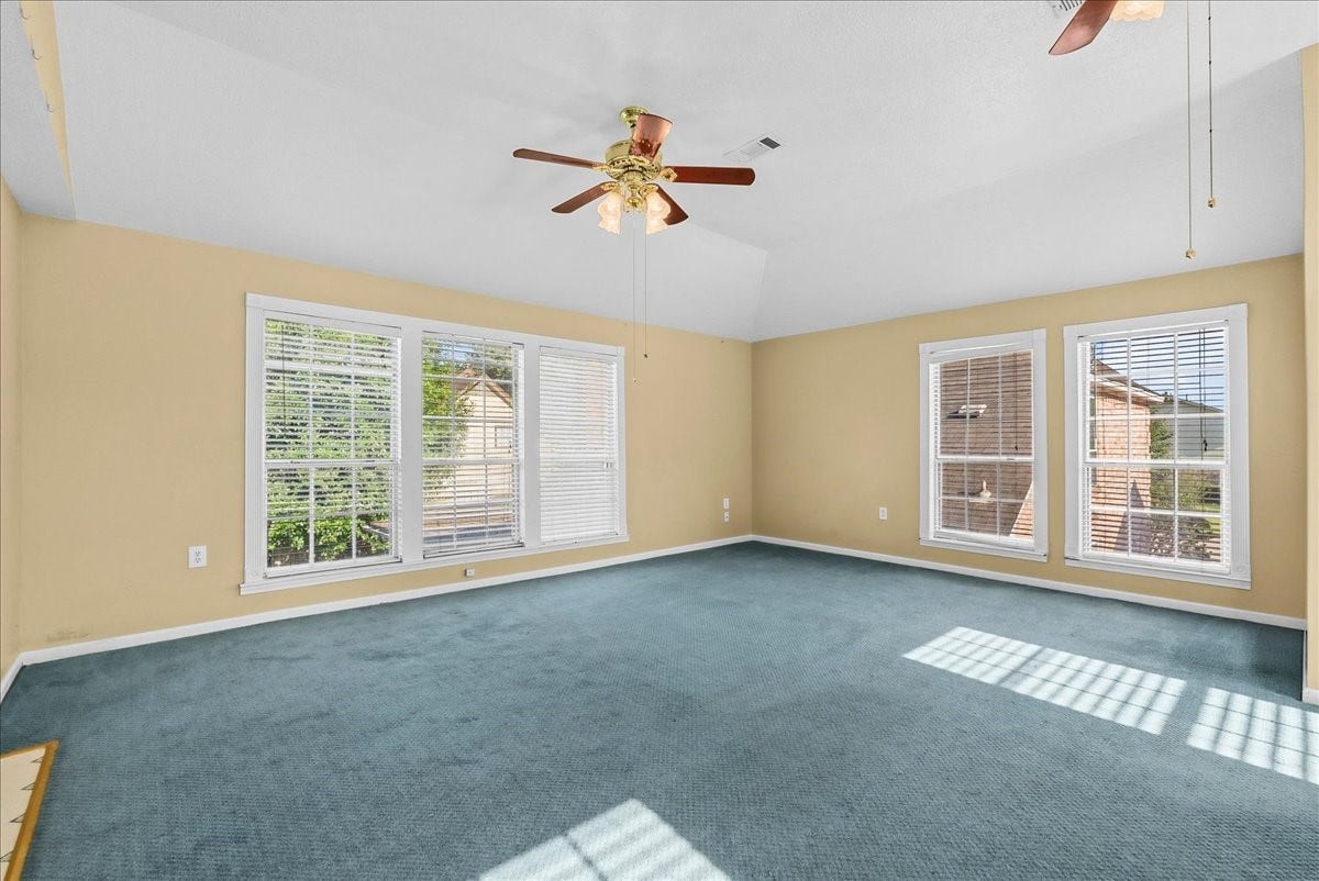 Experience bright, spacious comfort in this inviting garage apartment living area, featuring large windows and a serene atmosphere.