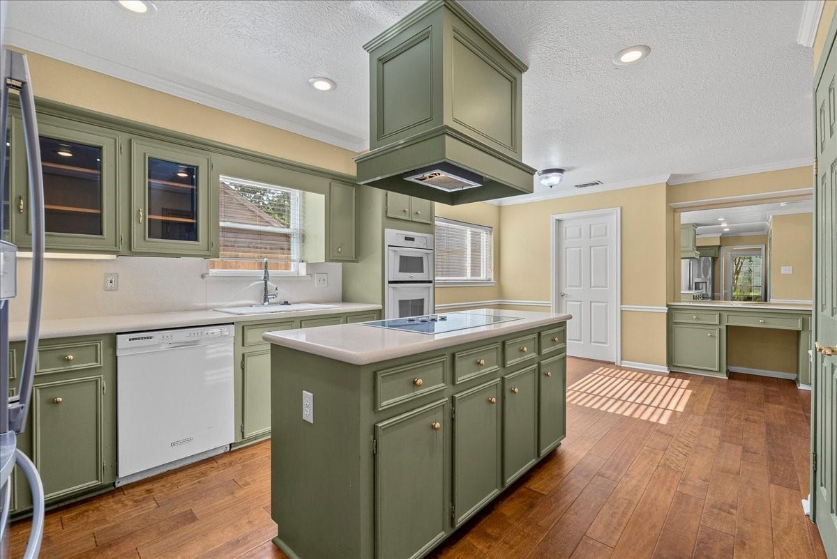 Discover culinary bliss in this inviting kitchen featuring a central island, perfect for cooking and gathering.