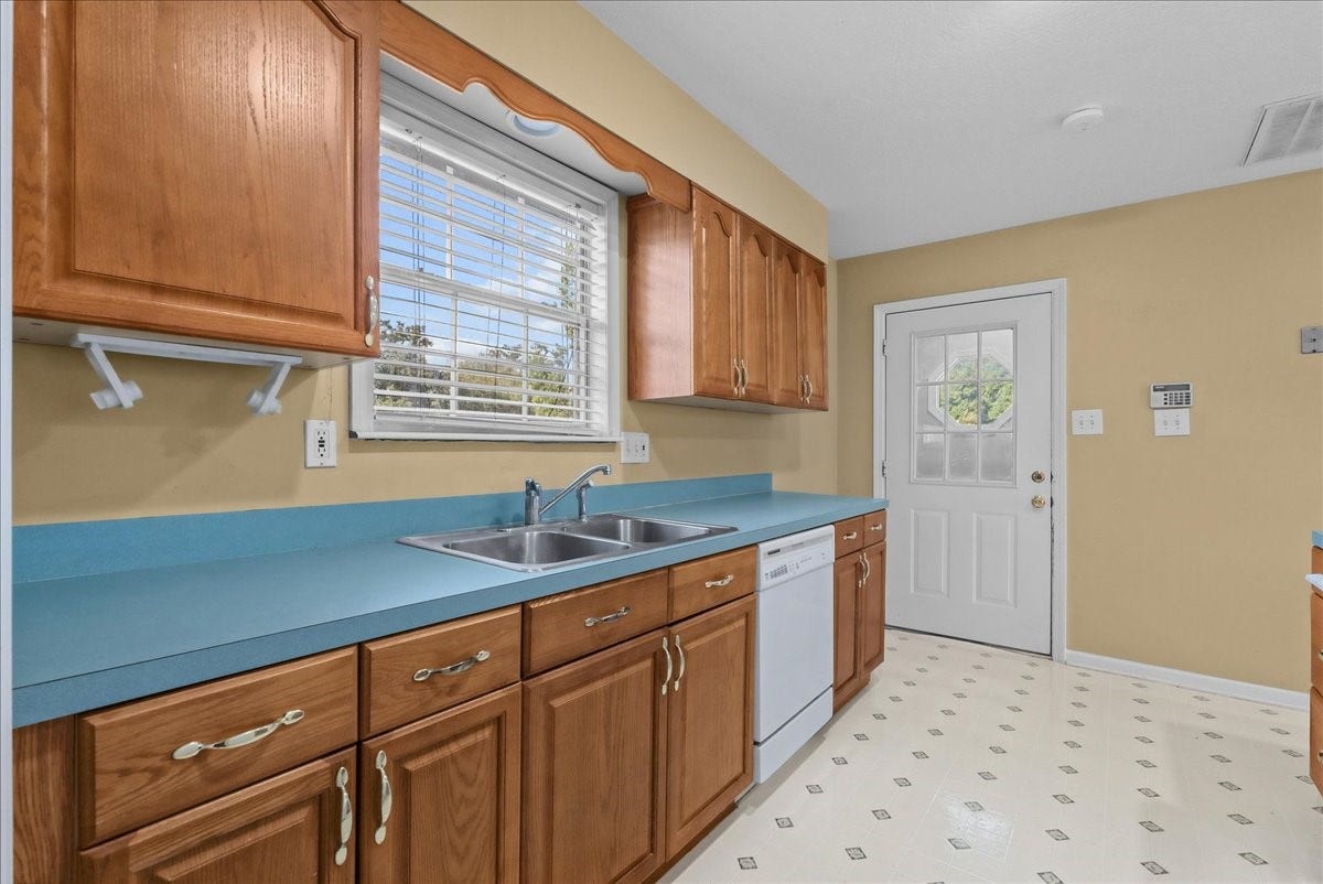 Charming garage apartment kitchen with warm wood cabinetry, sleek countertops, and ample natural light, offering a cozy and inviting space.