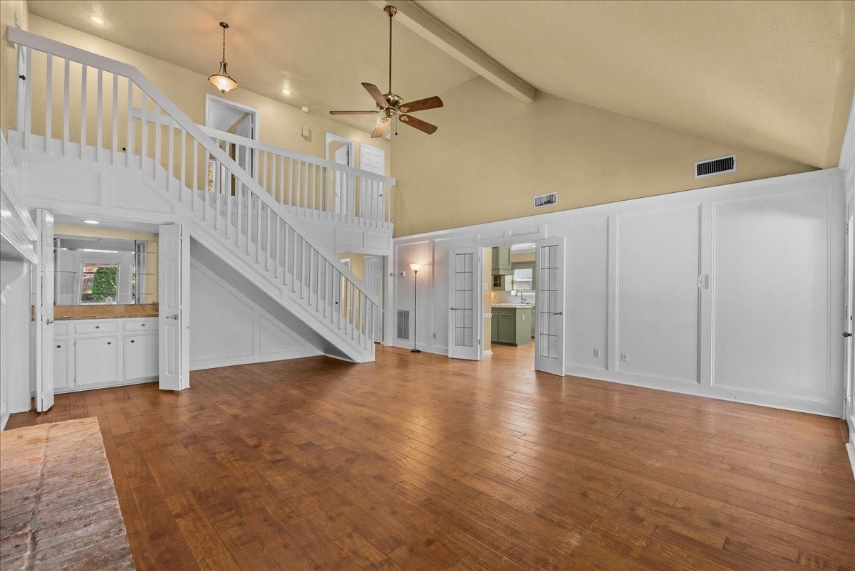 Expansive living room with soaring ceilings and a stylish wet bar, perfect for entertaining and relaxation.