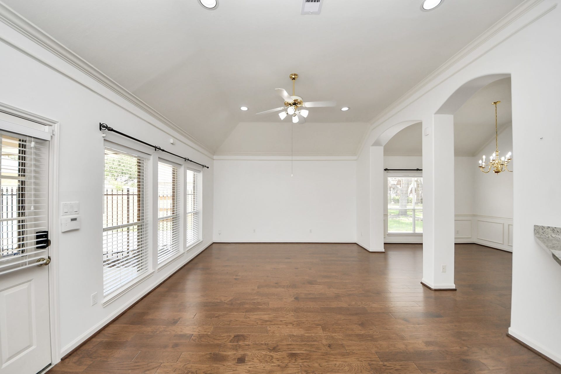 5815 Pheasant Ridge Lane, Houston, TX 77041 Spacious, light-filled living area with elegant hardwood floors, vaulted ceilings, and stylish arched entryways.