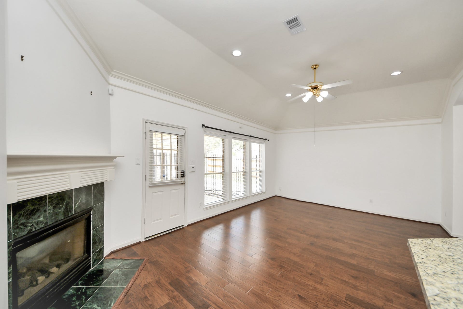 5815 Pheasant Ridge Lane, Houston, TX 77041 Spacious bedroom with elegant wood flooring, a cozy fireplace, and abundant natural light from large windows, perfect for relaxation and entertaining.