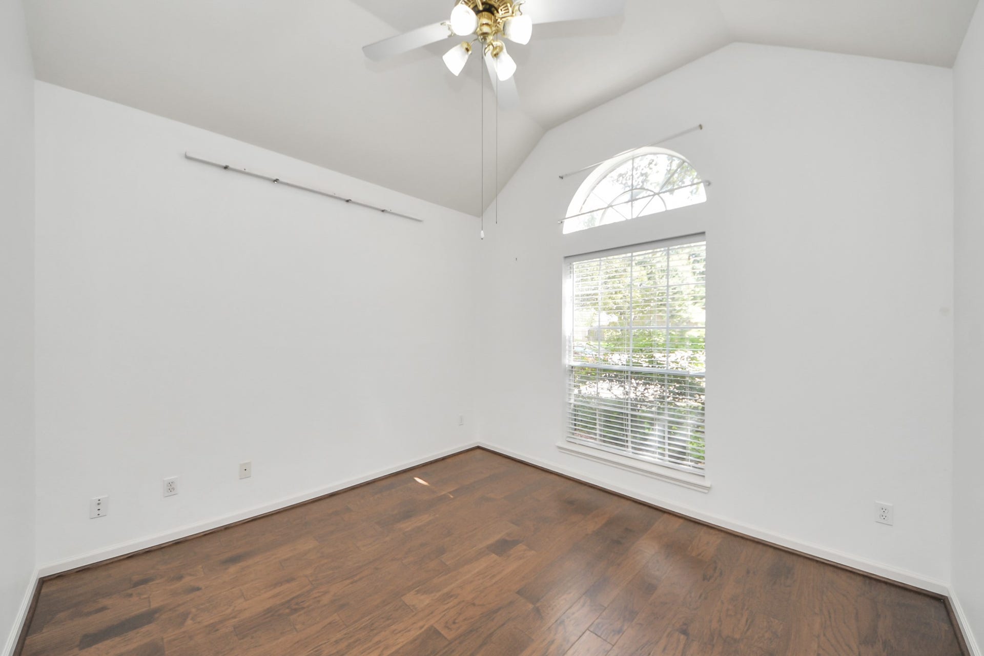 5815 Pheasant Ridge Lane, Houston, TX 77041 Bright room with vaulted ceiling, wood flooring, and a large window, perfect for natural light.