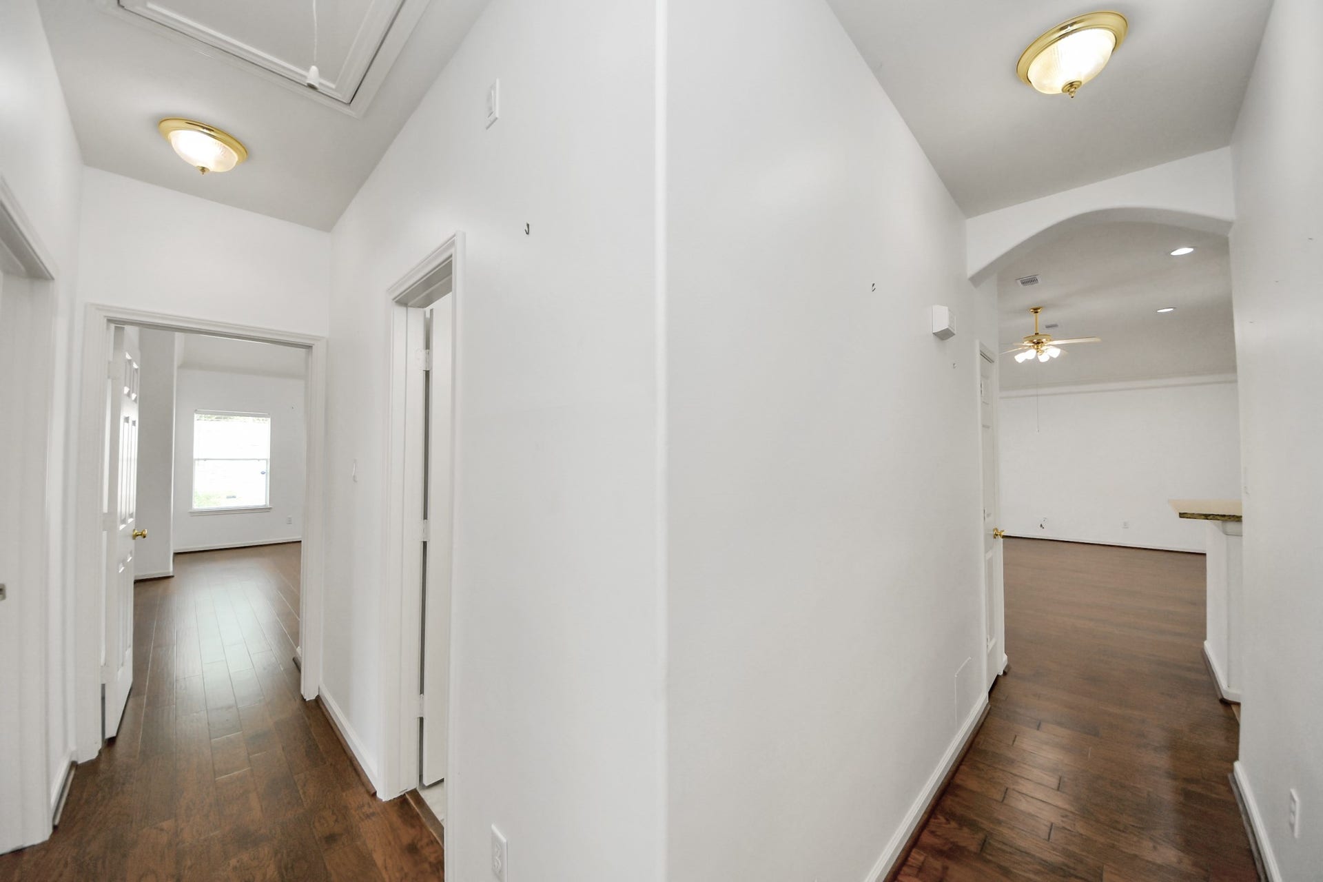 5815 Pheasant Ridge Lane, Houston, TX 77041 Bright and spacious hallway with warm wood flooring, leading to multiple rooms and featuring stylish ceiling lights.
