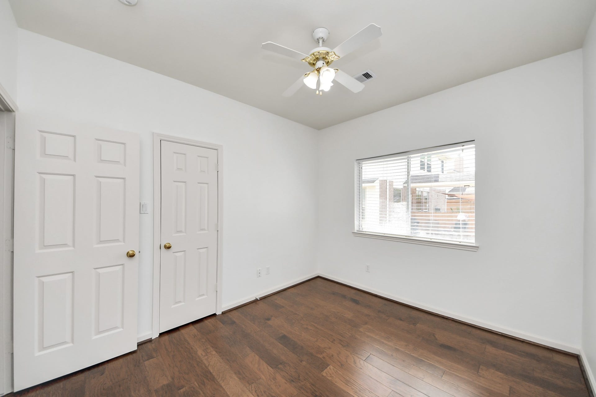 5815 Pheasant Ridge Lane, Houston, TX 77041 Bright and airy bedroom featuring hardwood flooring, a ceiling fan, and ample natural light from a large window.