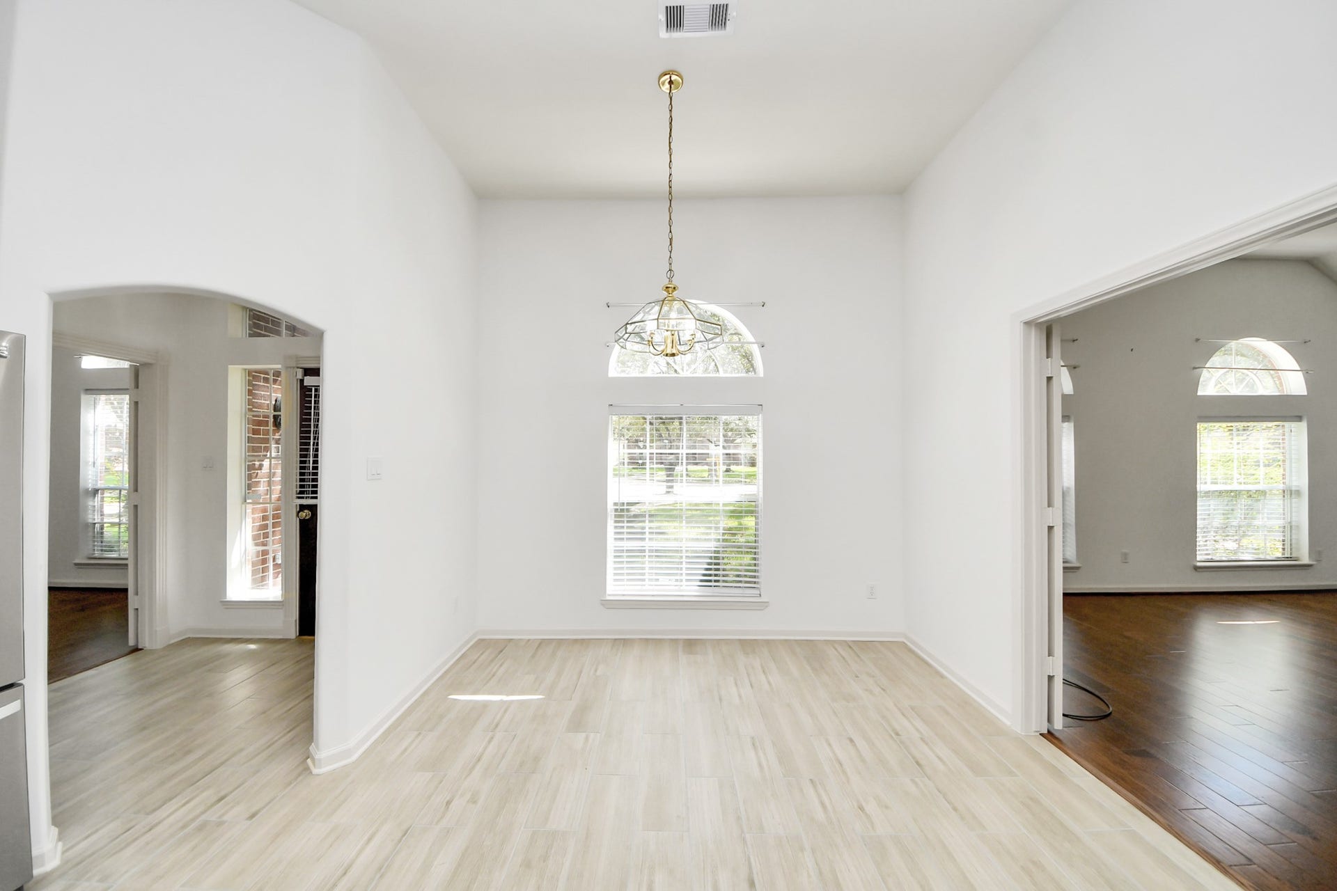 5815 Pheasant Ridge Lane, Houston, TX 77041 Bright and airy room with elegant light wood flooring, high ceilings, and large arched windows allowing abundant natural light.