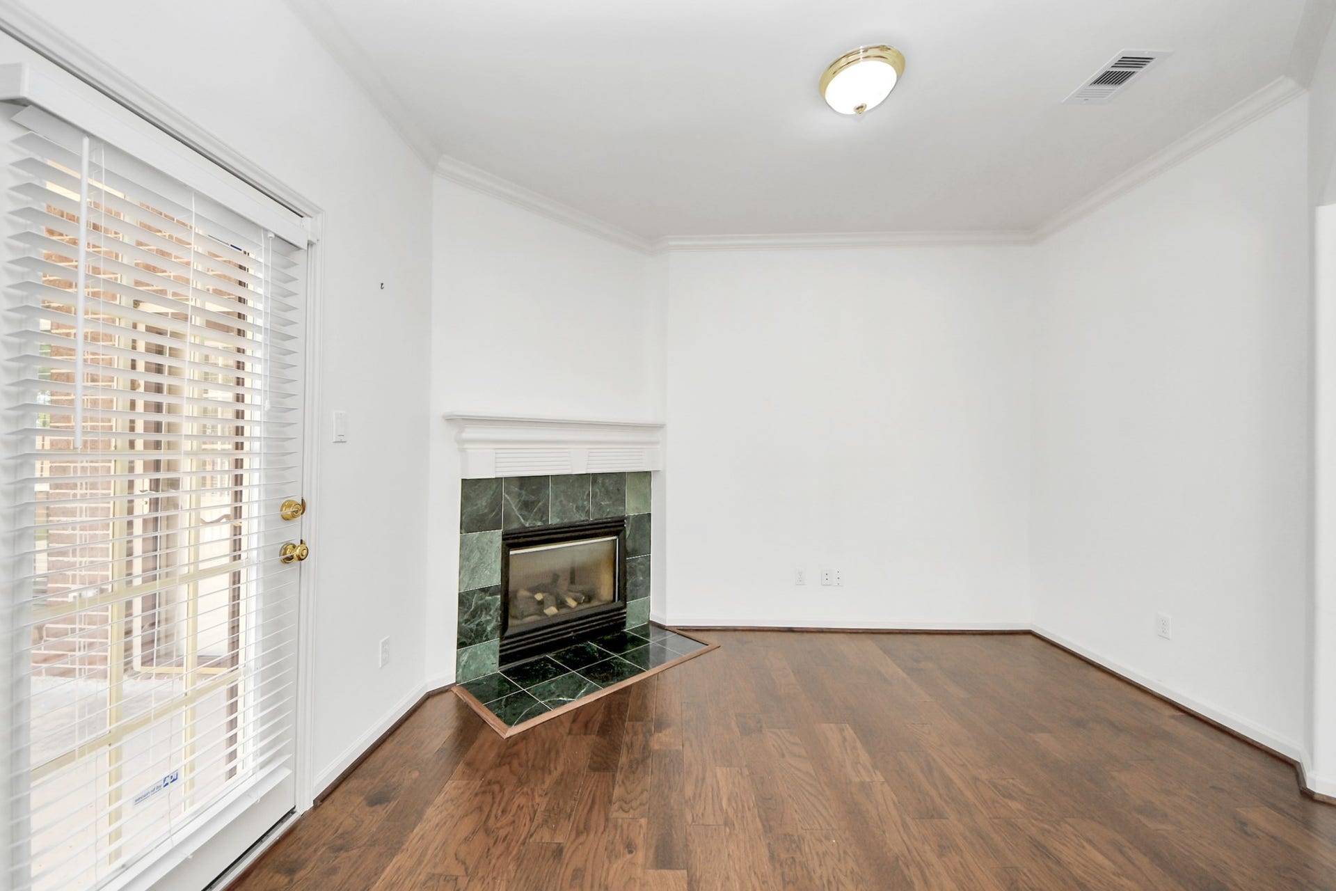 5815 Pheasant Ridge Lane, Houston, TX 77041 Charming Bedroom with elegant hardwood floors, a cozy corner fireplace, and abundant natural light from French doors.