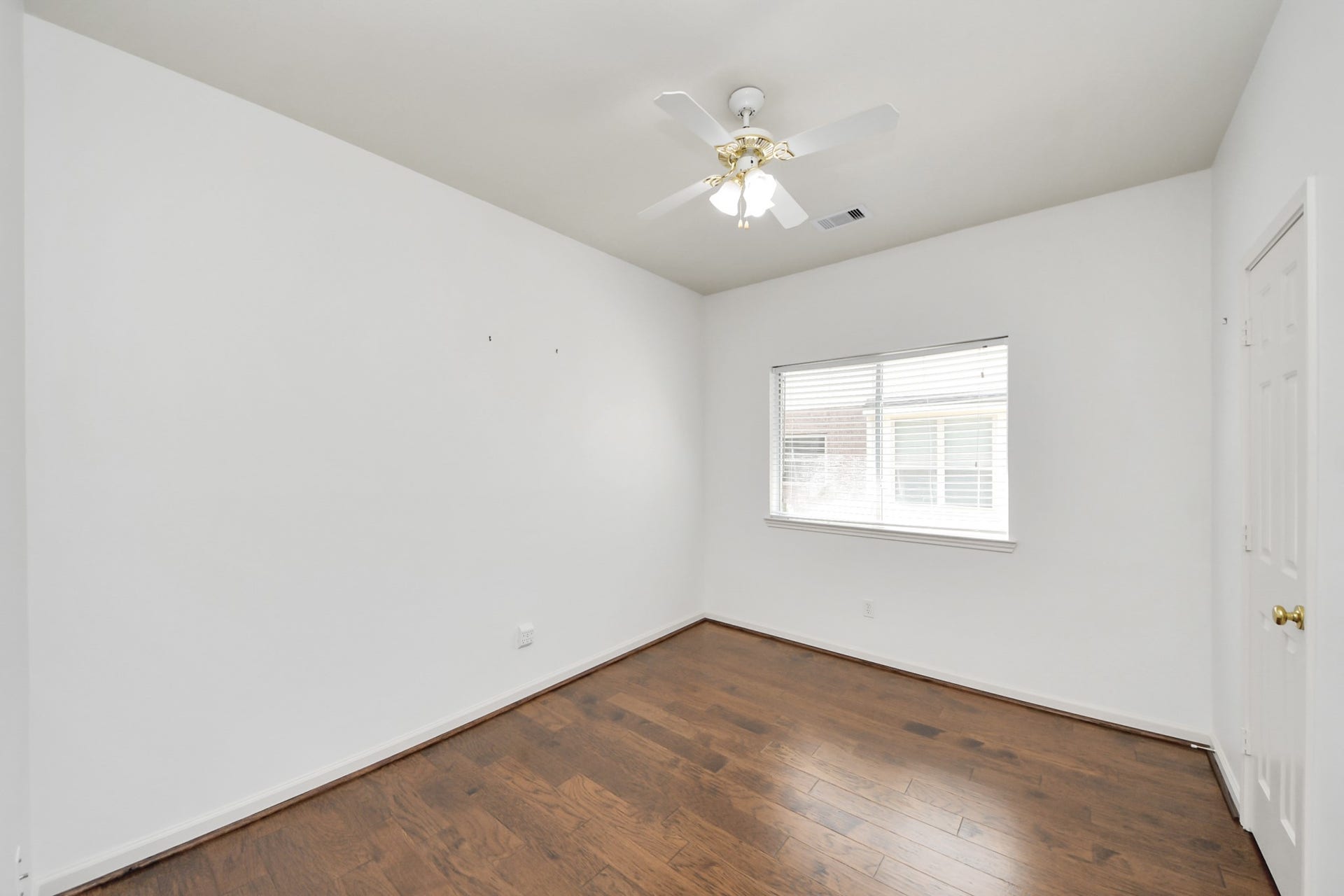 5815 Pheasant Ridge Lane, Houston, TX 77041 Bright bedroom featuring hardwood floors, a ceiling fan, and a large window for natural light.