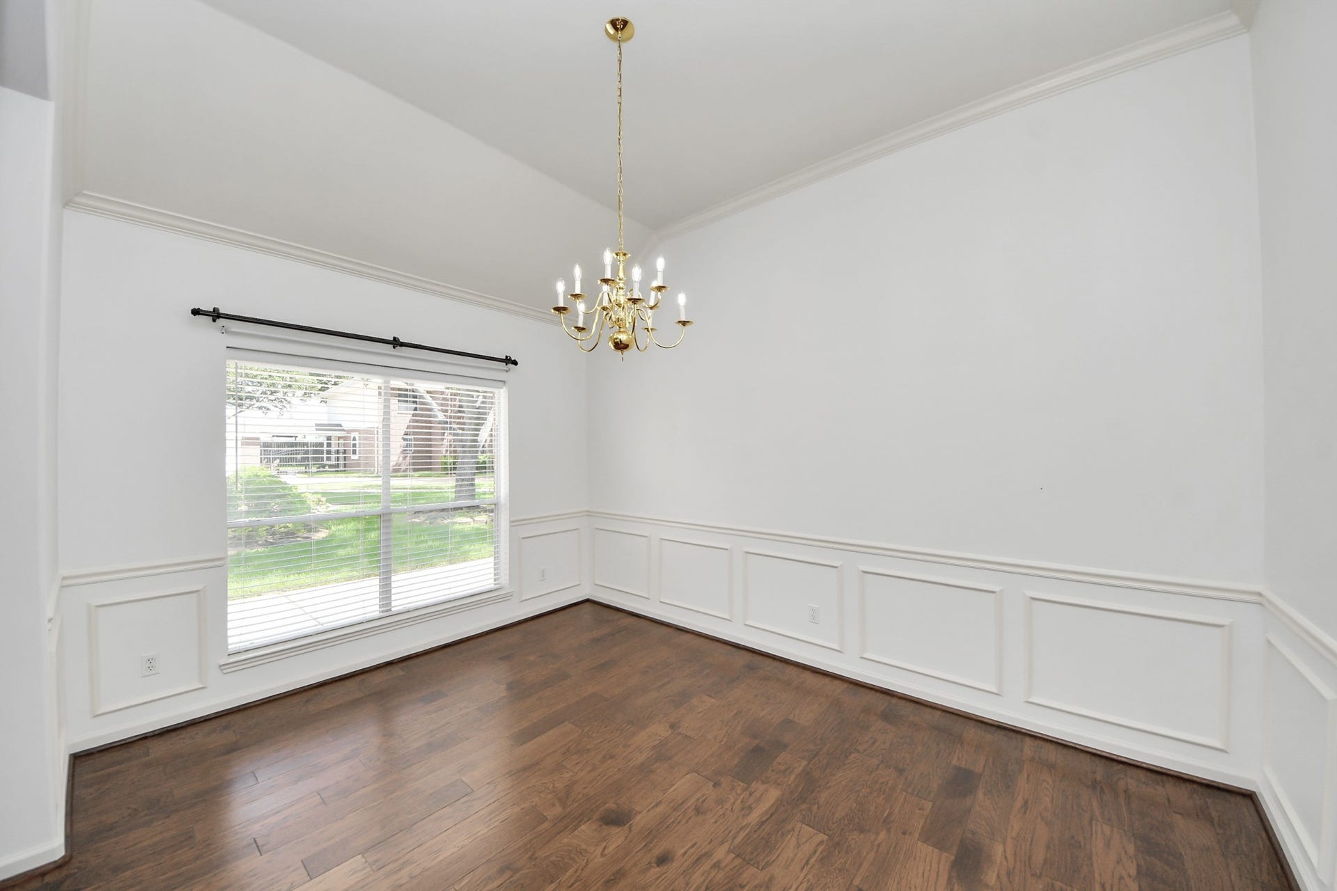 5815 Pheasant Ridge Lane, Houston, TX 77041 Elegant dining room featuring rich hardwood floors, a classic chandelier, and a large window offering abundant natural light.