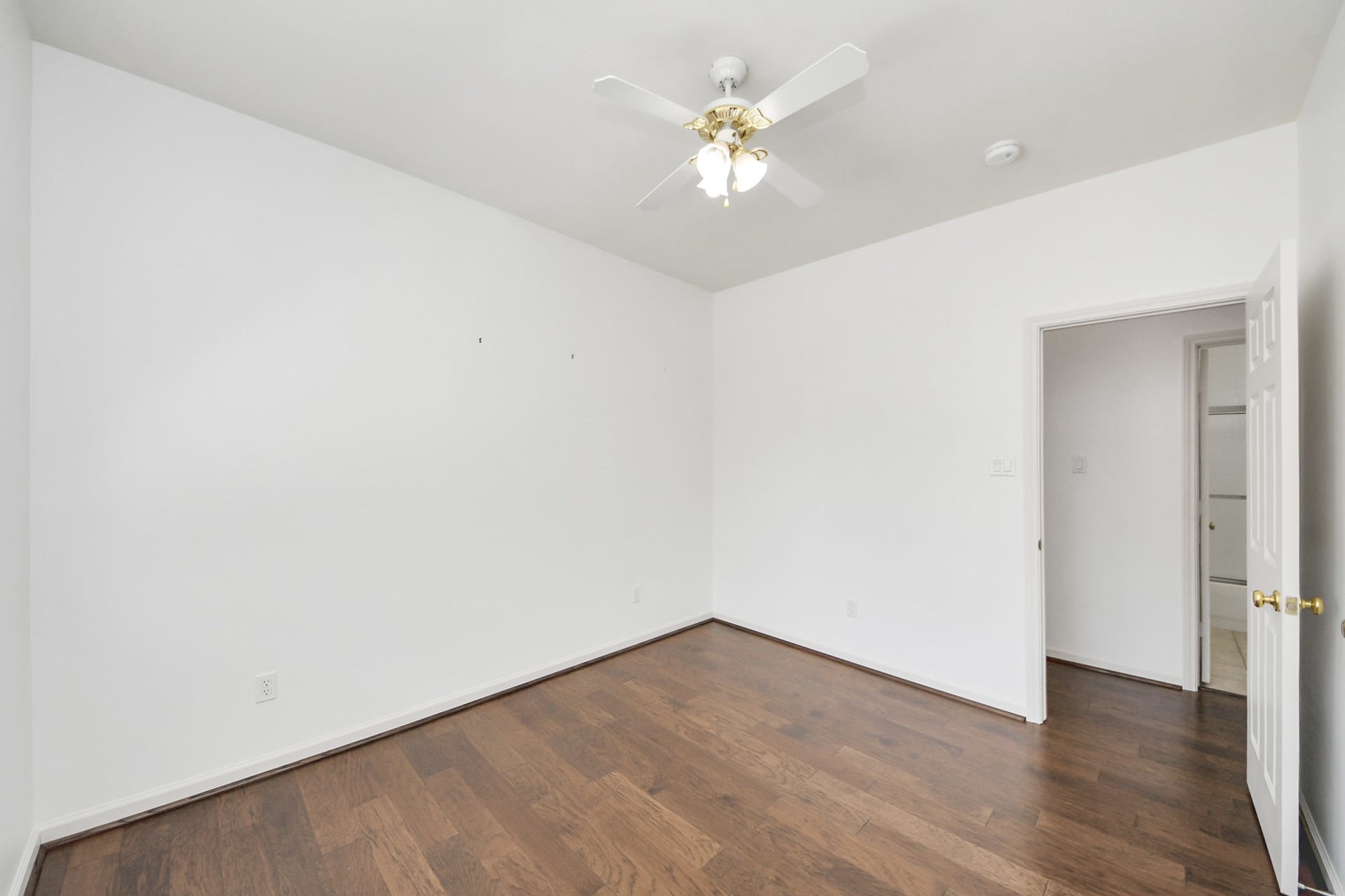 5815 Pheasant Ridge Lane, Houston, TX 77041 Bright and airy room with rich hardwood floors and a ceiling fan, offering a blank canvas ready for your personal touch.