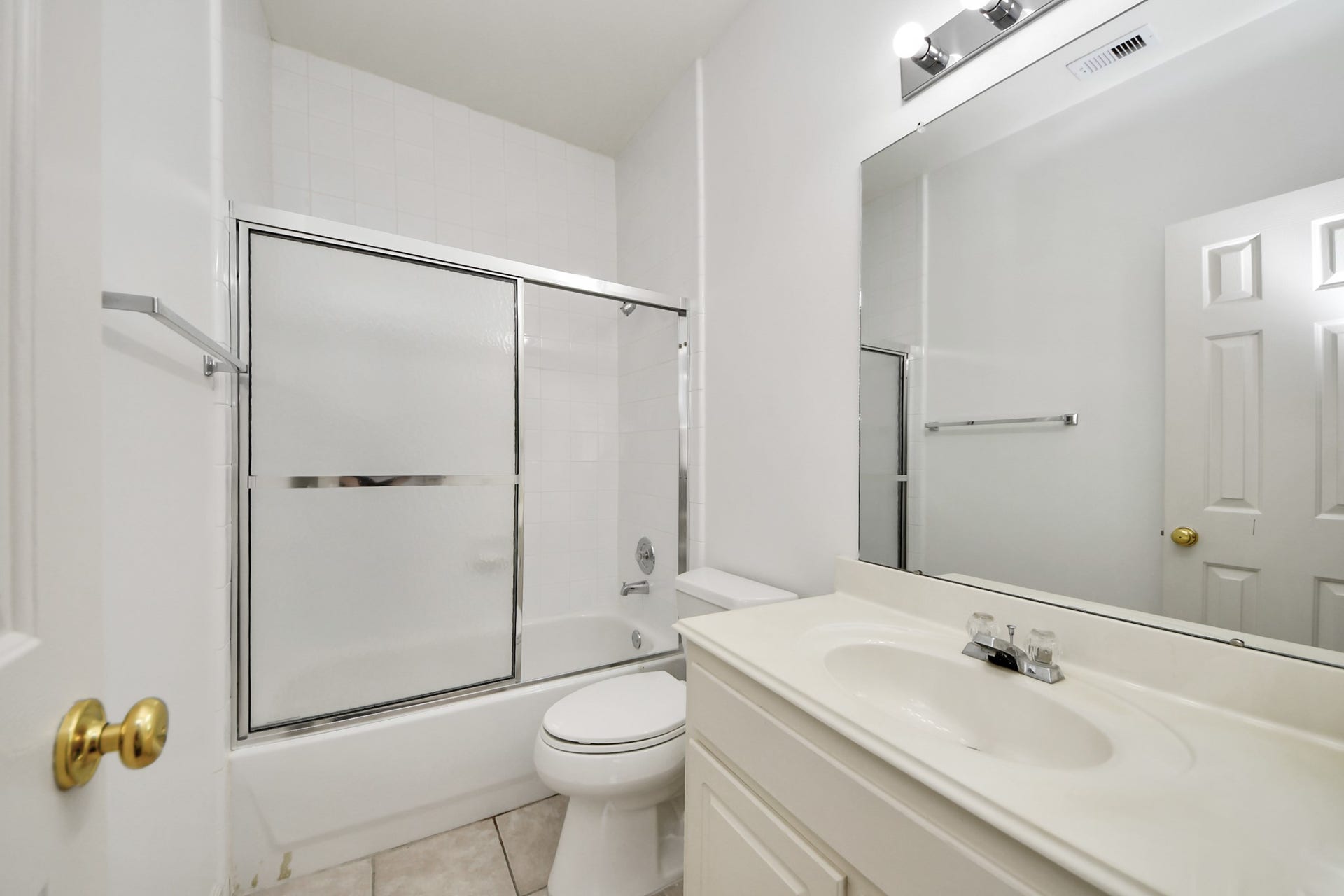 5815 Pheasant Ridge Lane, Houston, TX 77041 Bright and clean bathroom featuring a sleek vanity, large mirror, and a shower-tub combo with sliding glass doors.