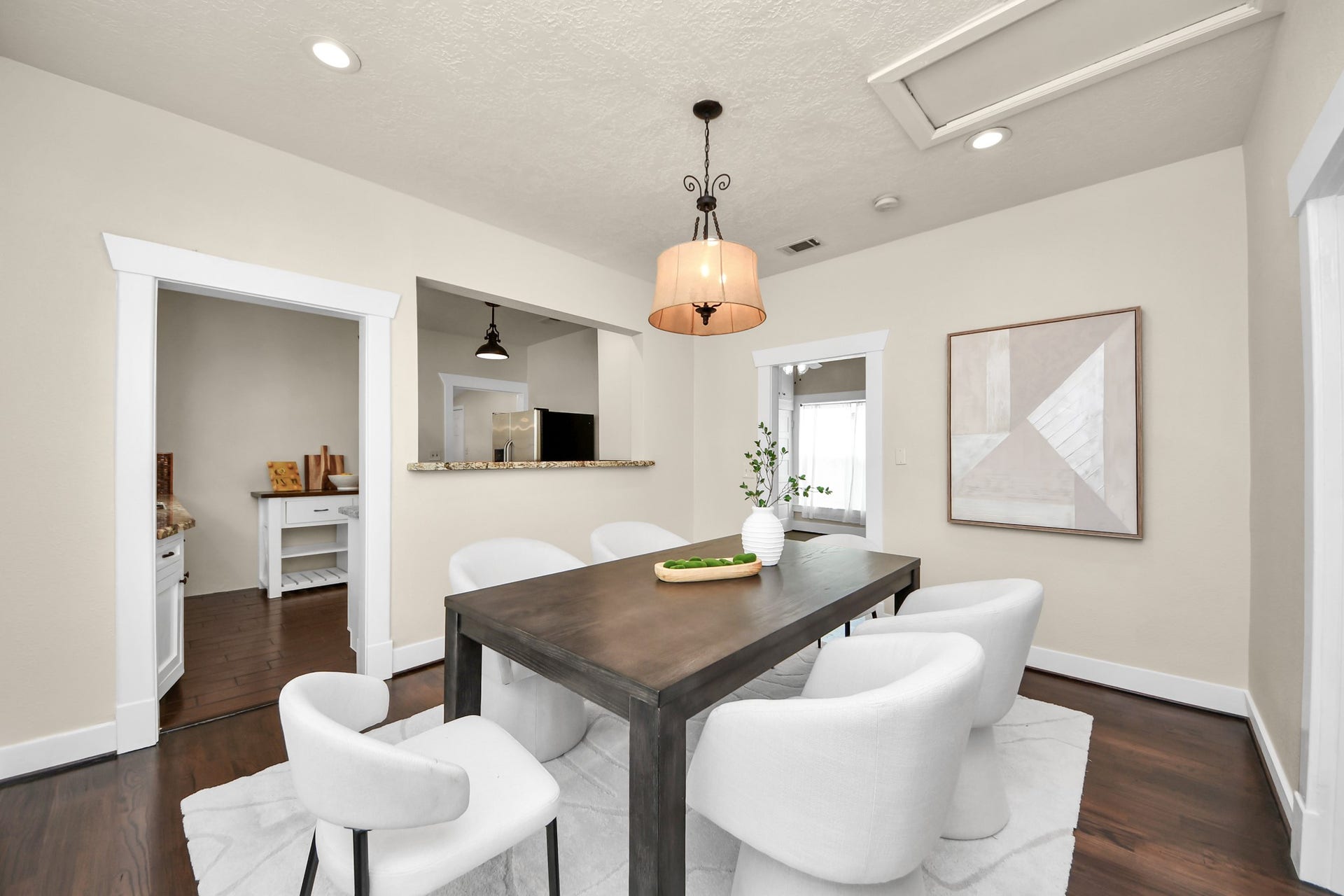 Inviting dining room with warm hardwood floors and an open kitchen pass-through for effortless flow throughout the space.