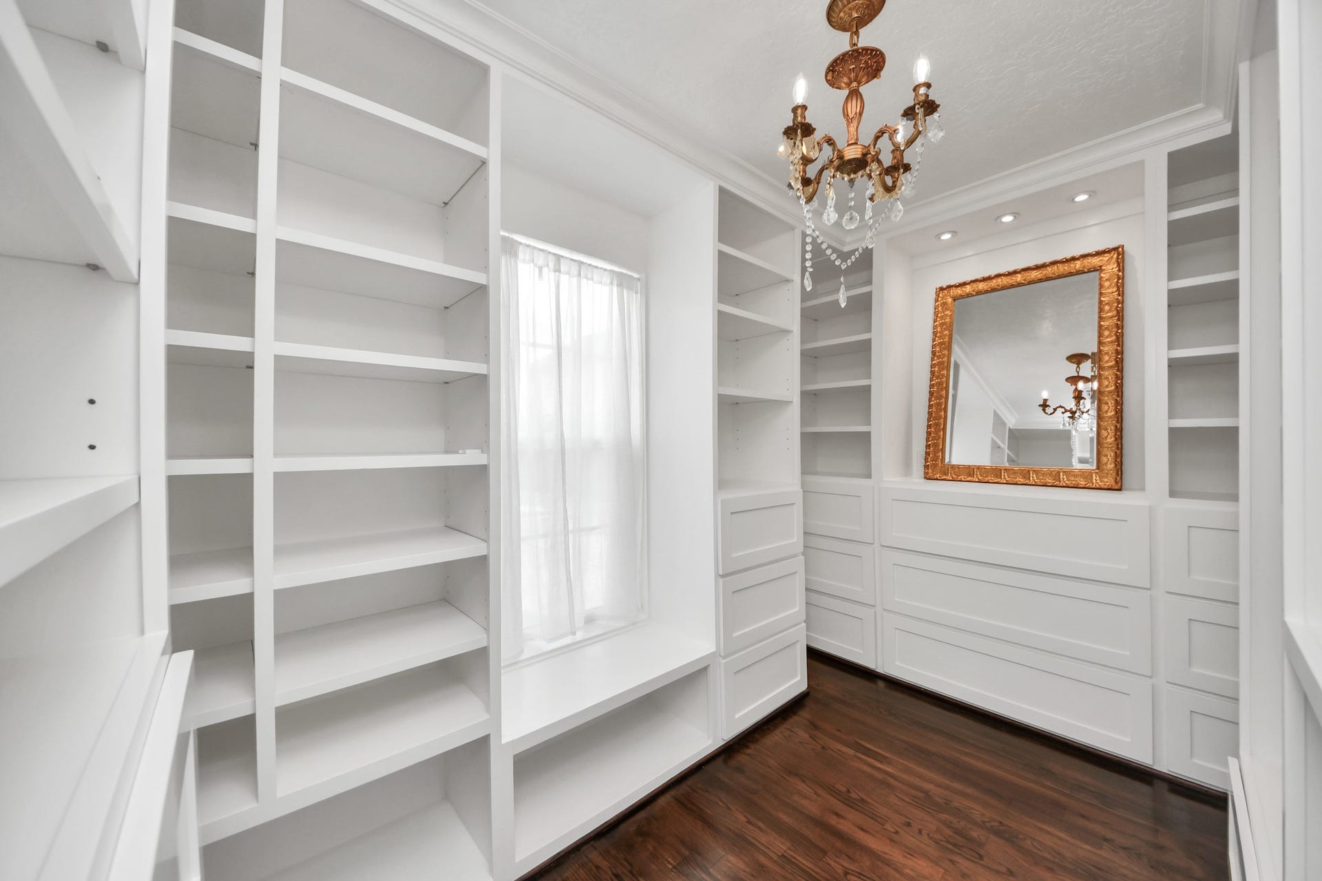 Boutique-inspired custom closet with extensive built-in shelving, drawers, and display space.