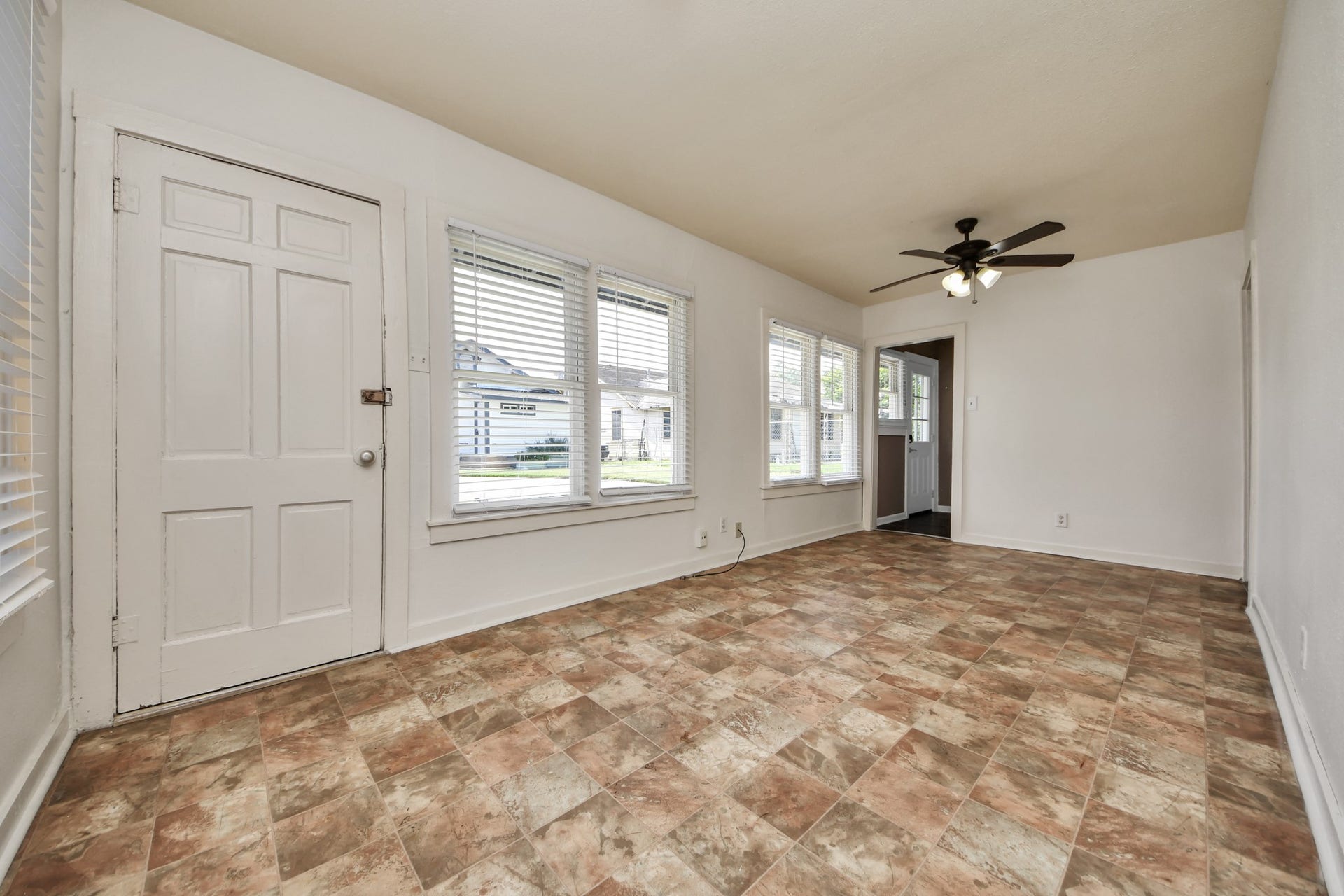 Sun-filled guest home living space featuring tile flooring, multiple windows, and ceiling fan. A comfortable and functional layout ready for immediate use.
