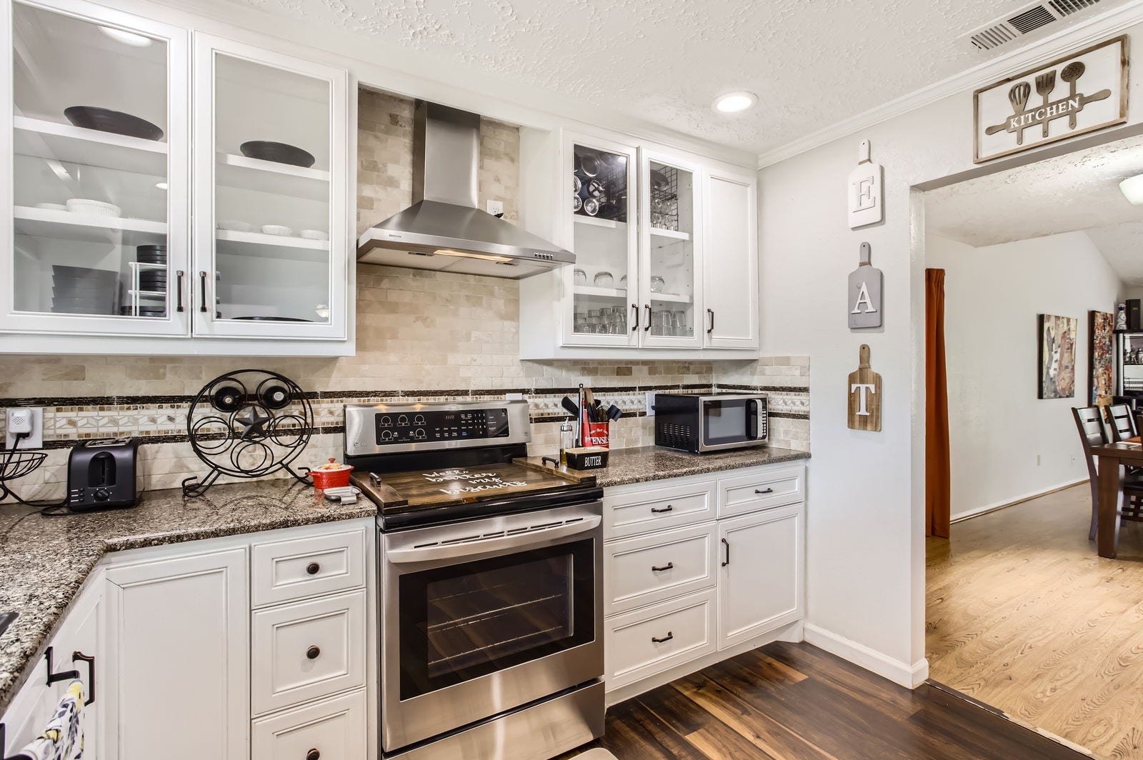 Kitchen features stainless steel electric range with vent hood.