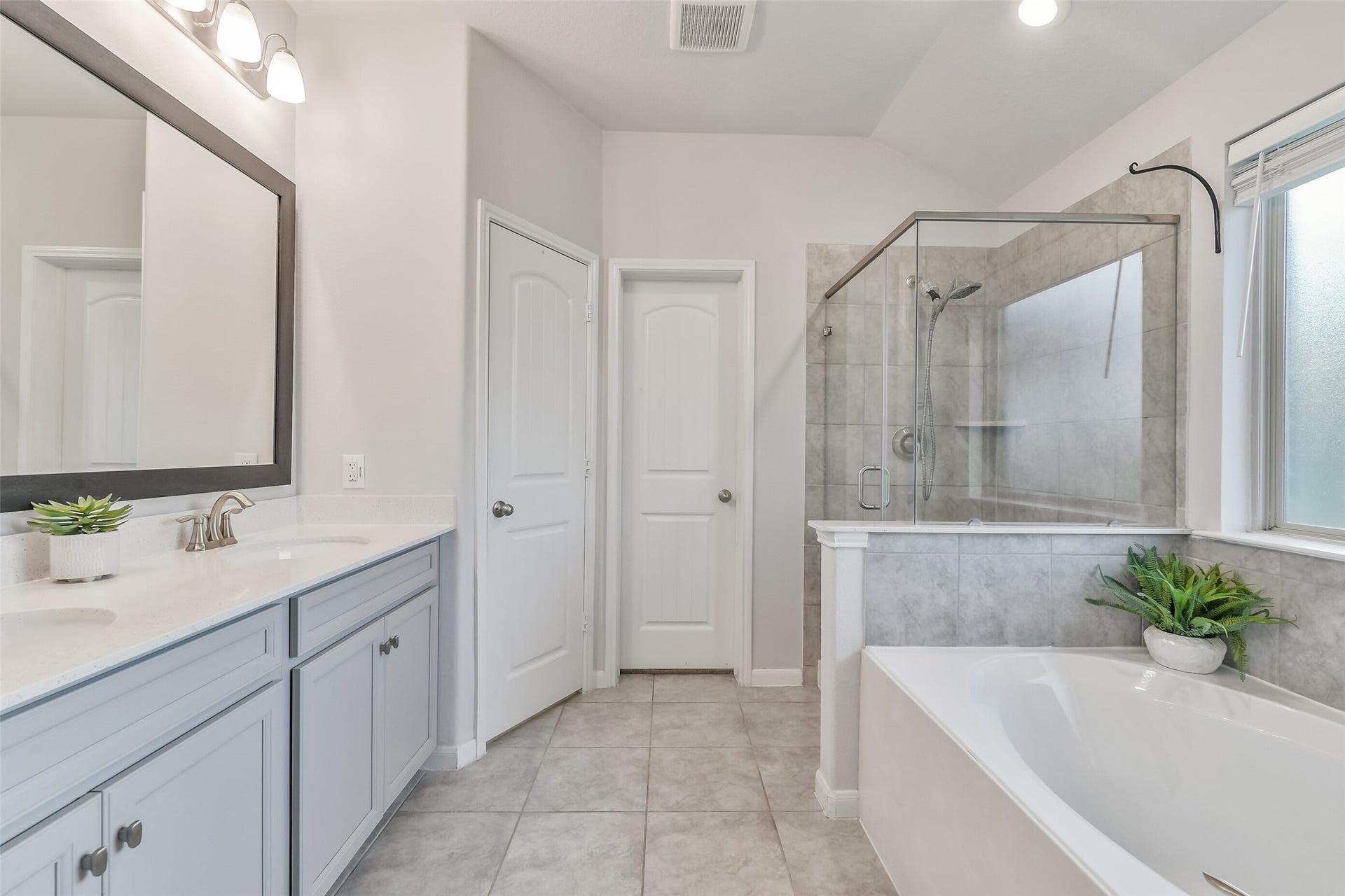 19450 Tobiano Park Drive, Tomball, TX 77377 The gorgeous primary bathroom features bright lighting, cabinetry, and a large walk in shower and soaking tub.