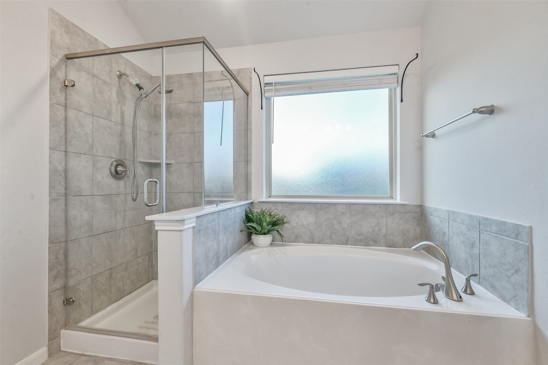 19450 Tobiano Park Drive, Tomball, TX 77377 The soaking tub features a large frosted window above for natural light.