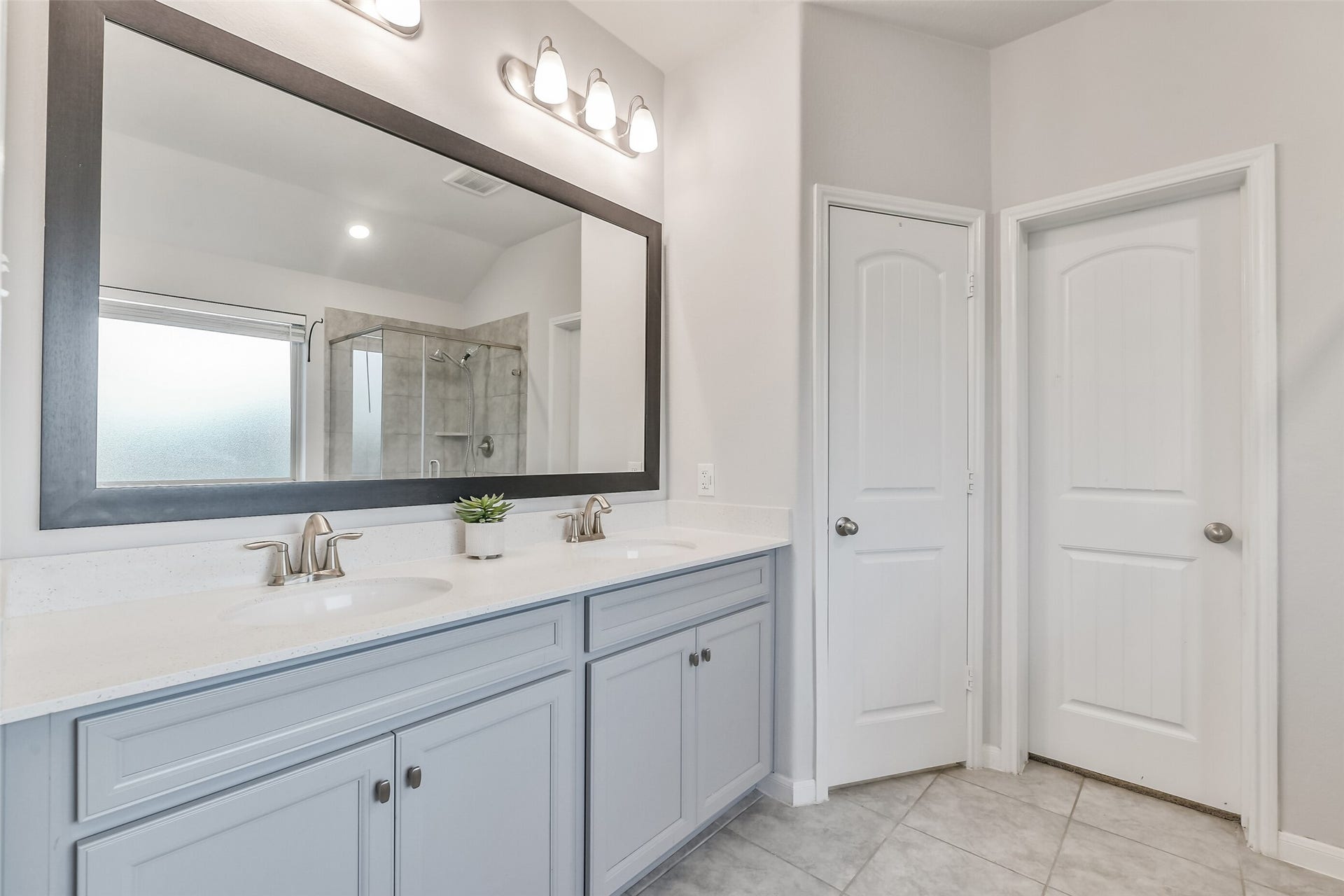 19450 Tobiano Park Drive, Tomball, TX 77377 A large mirror and double sinks offers plenty of space for two people to get ready for the day.
