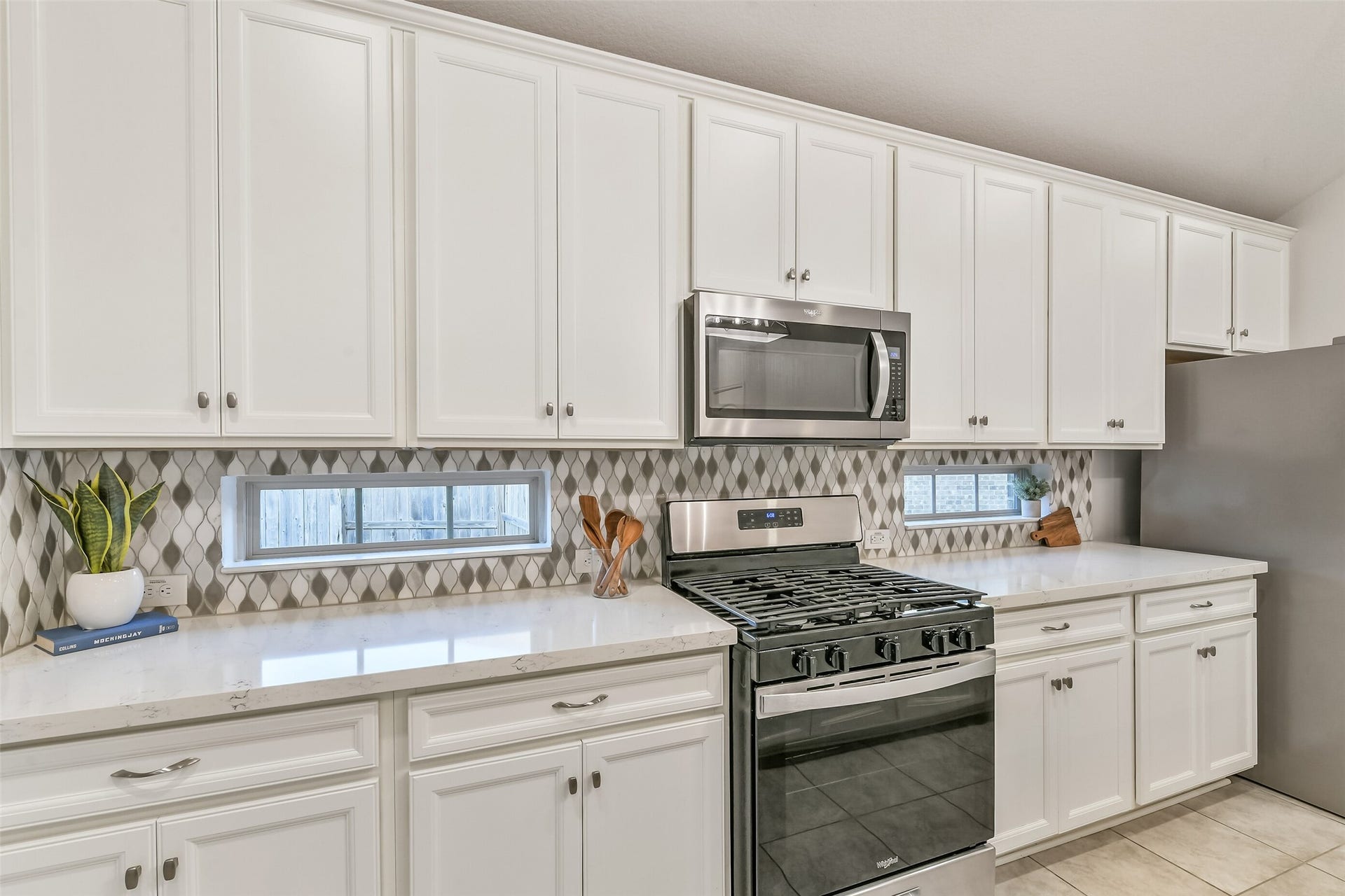 19450 Tobiano Park Drive, Tomball, TX 77377 This kitchen features designer backsplash with windows allowing for natural light in the area.