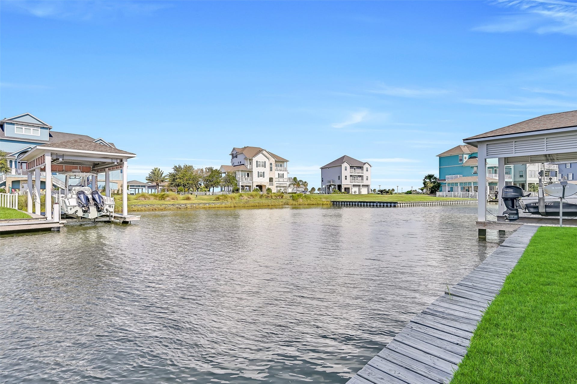 12 Fleming, Hitchcock, TX 77563 This is the view that sells itself. Looking down the canal at 12 Fleming, you see exactly what waterfront living on the Texas Gulf Coast is meant to look like a private boathouse with a 30-foot electric lift, a fully rebuilt dock, lush landscaping, and a stunning three-story home rising above the water behind it. The Flamingo Isles MUD maintains the bulkheads and canal depths so the water stays navigable year round. From this angle, it is easy to understand why buyers who discover Harborwalk rarely look a