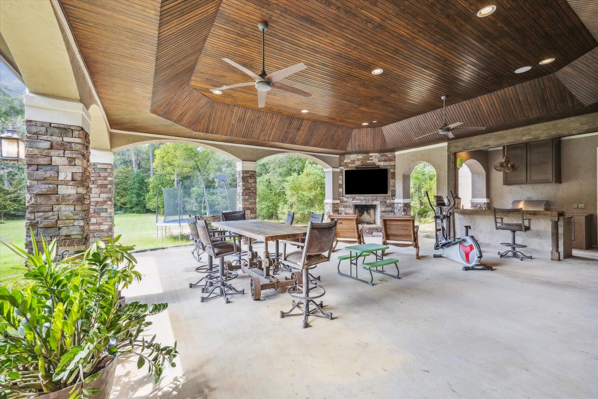 Stunning outdoor covered patio off of game room and kitchen with fireplace and outdoor kitchen - perfect for entertaining!